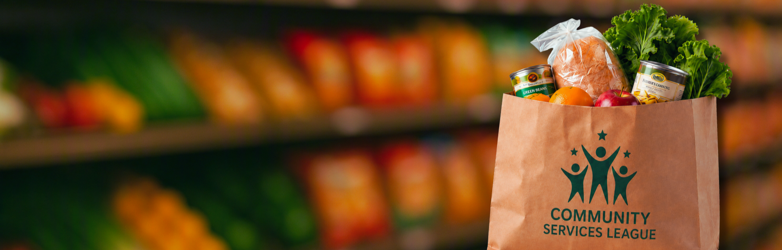 Brown paper grocery bag with fresh produce and canned goods, labeled with the 'Community Services League' logo, placed in a grocery store aisle.