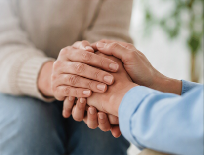 Two people holding hands in a comforting gesture.
