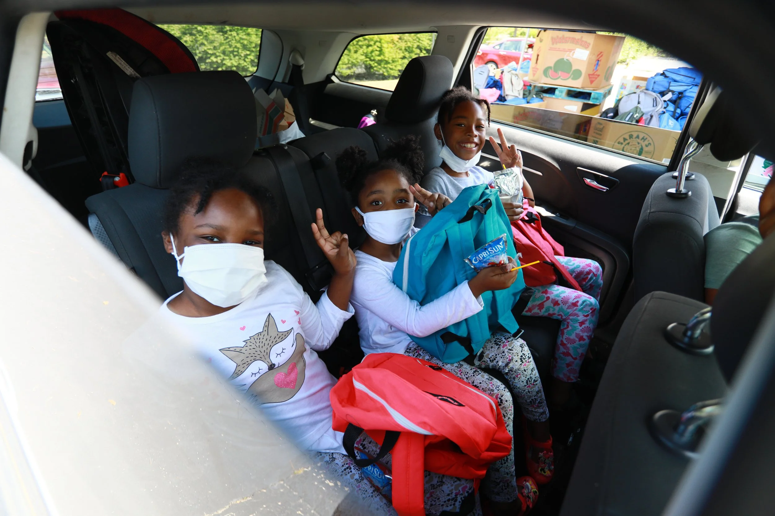 Local students smiling with backpacks received through CSL’s Back to School program