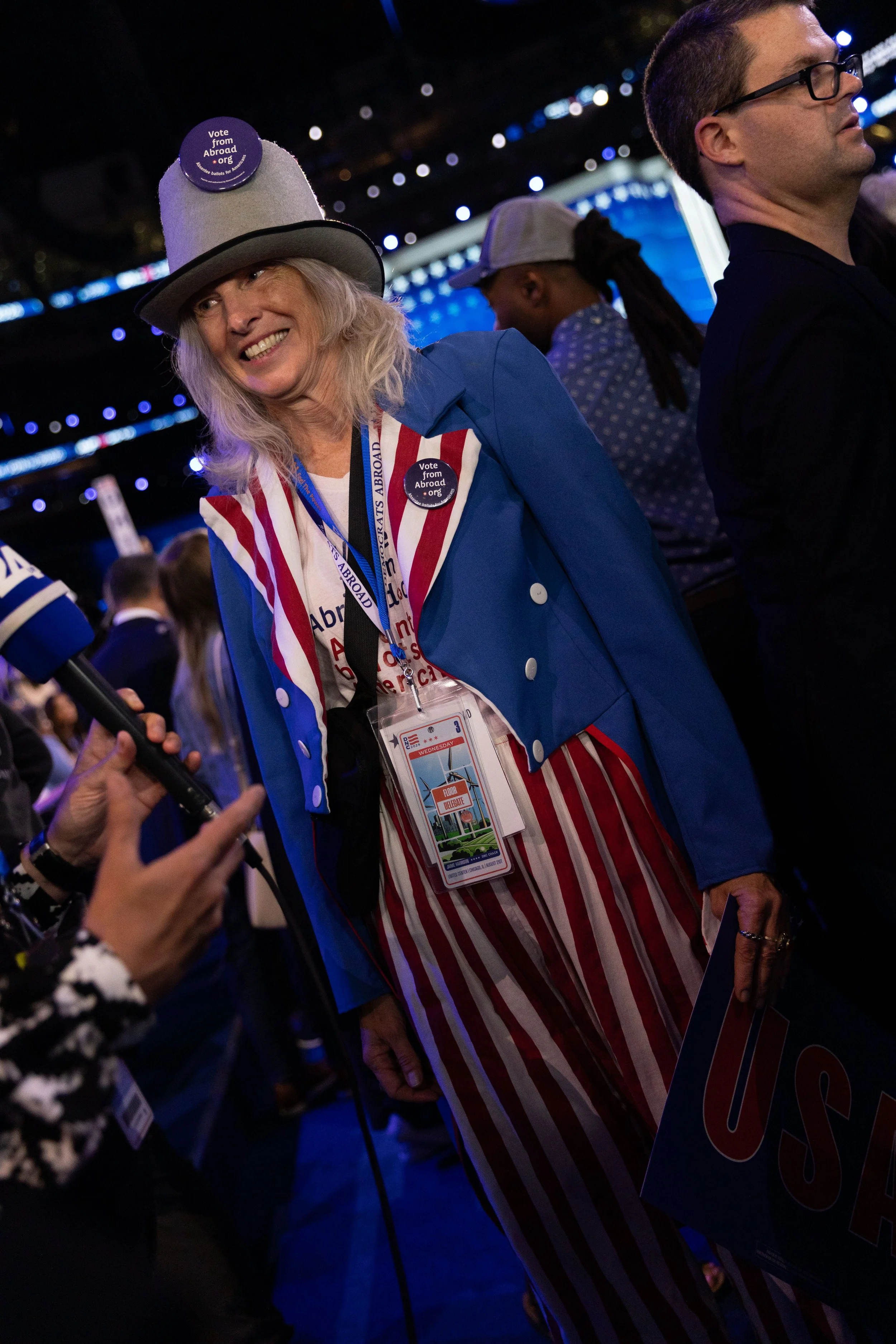 Sue Alksnis, a delagate and spokesperson for Democrats Abroad speaks with a broadcast reporter dressed in her rendition of "Uncle Sam" as "Aunt Sam," on the third day of the Democratic National Convention on Aug. 21, 2024.