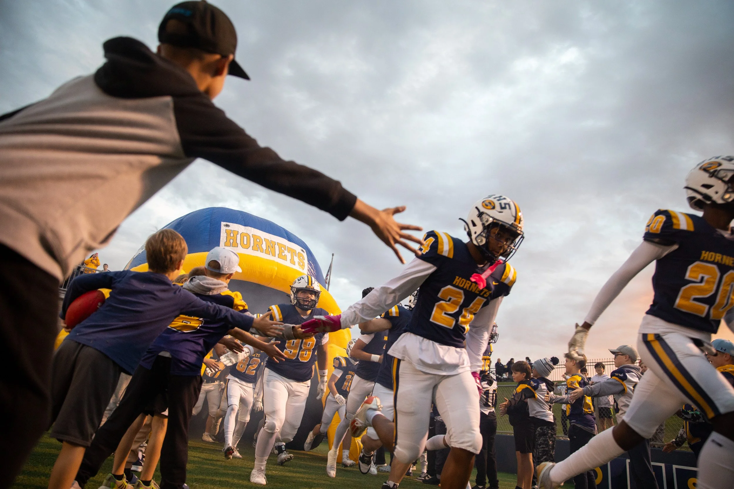 Saline High School football players run out onto the field before a high school football game at Saline High School on Friday, Oct. 10, 2025. 