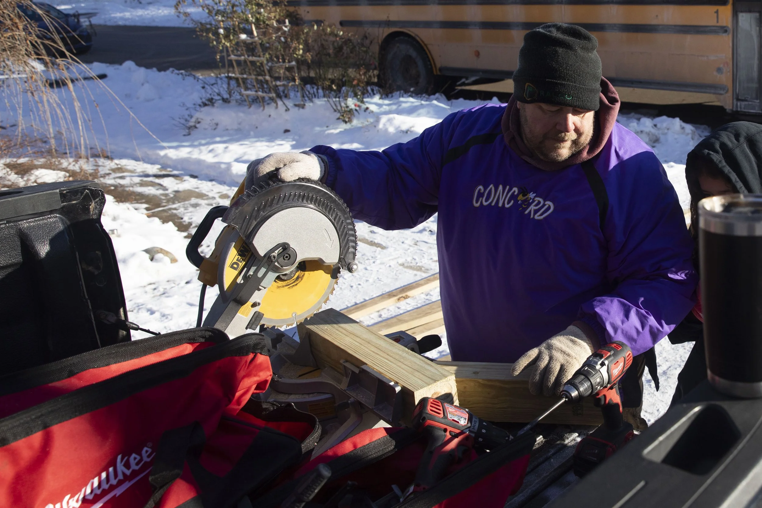 Mike Arbuckle, an industrial arts teacher at Concord Middle School, shows students how to cut wood as he works on building a ramp for a student's father who became disabled after a crash a year ago. Arbuckle lead the project and installment outside o