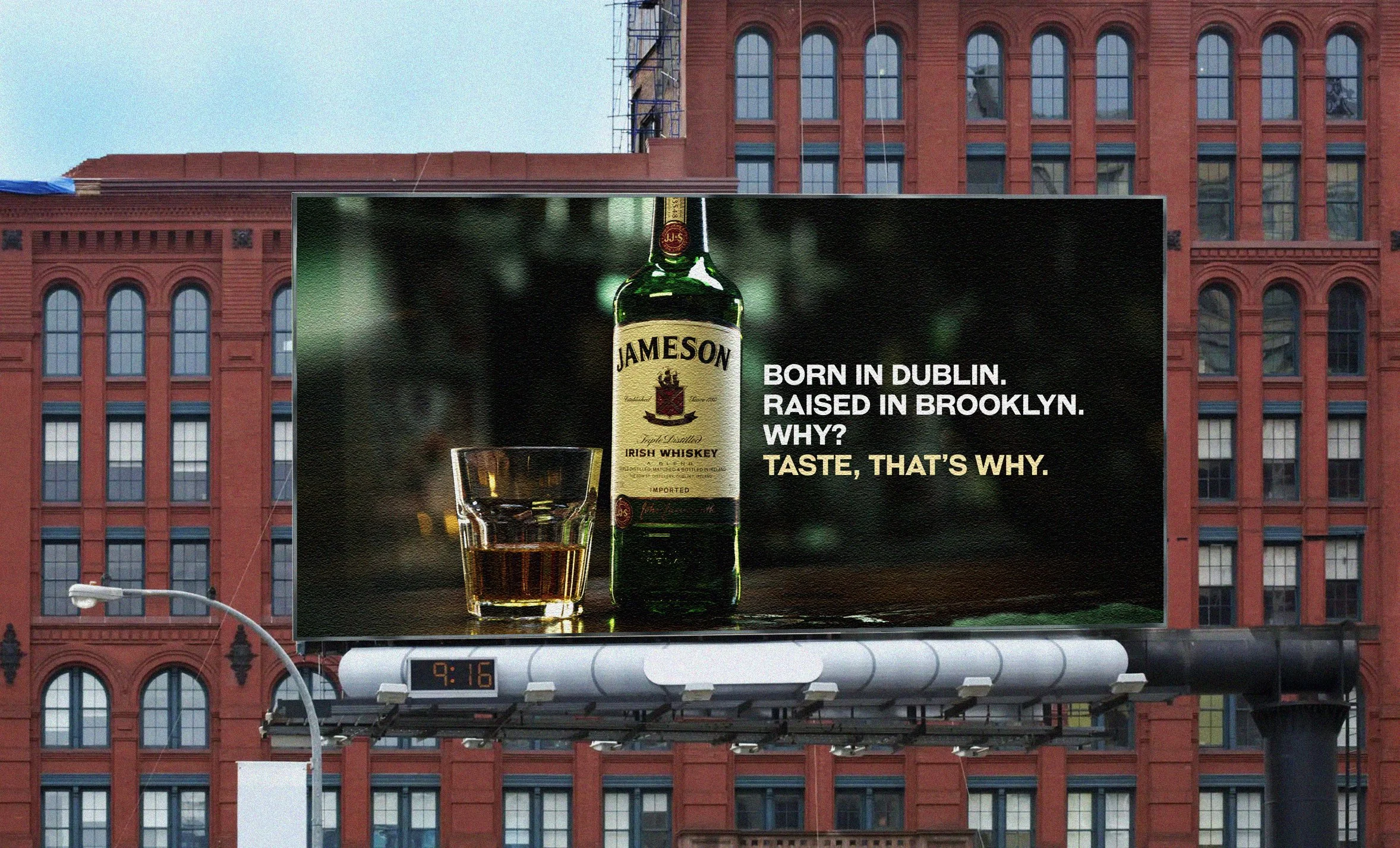 Billboard advertisement featuring a bottle of Jameson Irish Whiskey and a glass of whiskey, with text emphasizing Dublin and Brooklyn origins, and a slogan about taste.