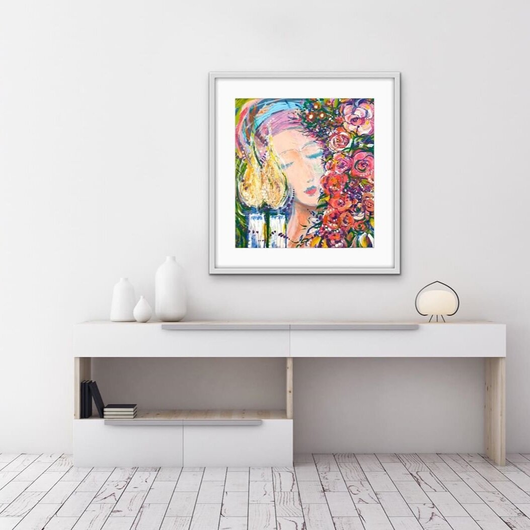 Judaica art by Roslyne Smith hanging on a wall above a white table