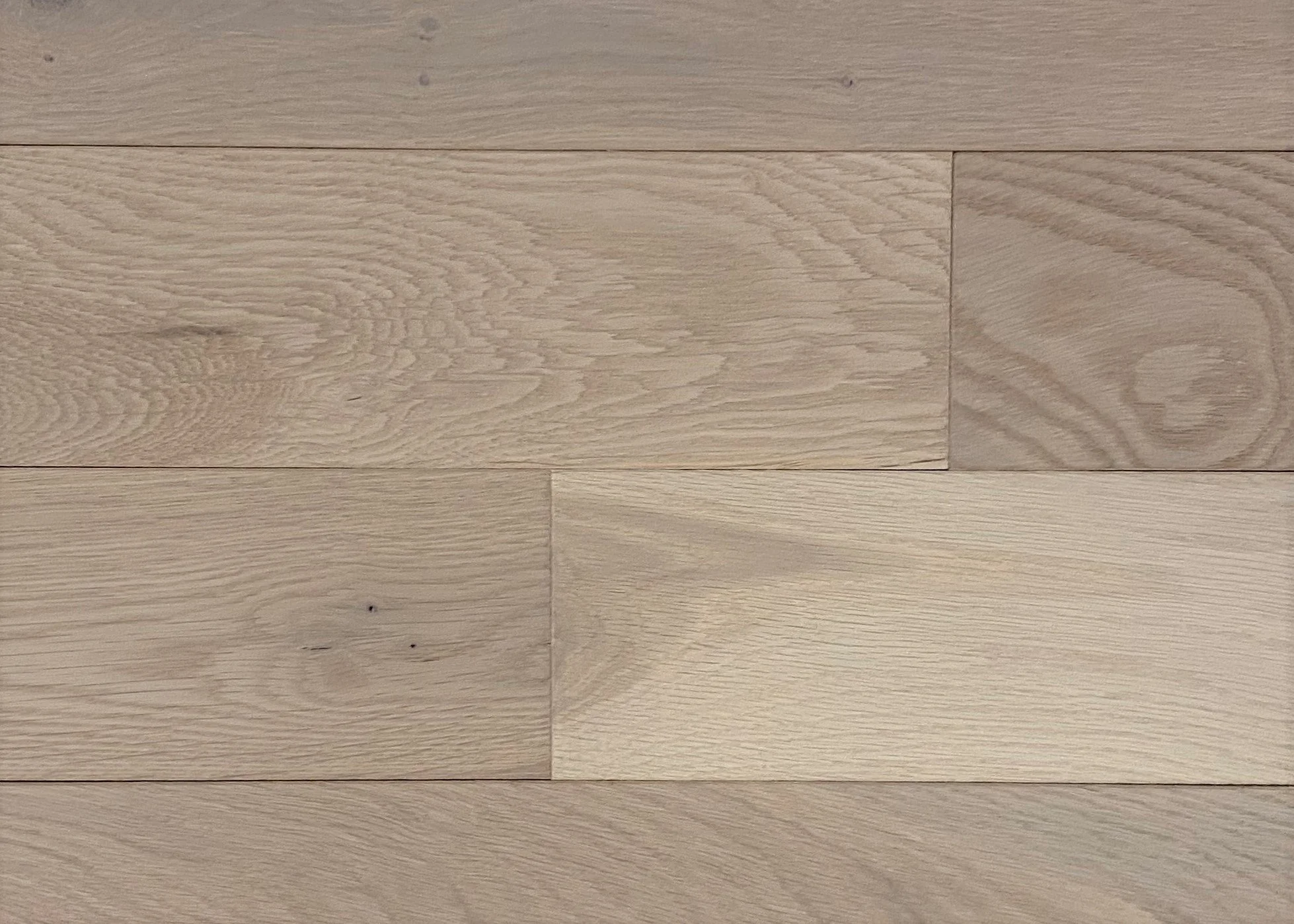 Close-up of light-colored wooden floorboards with visible wood grain patterns.
