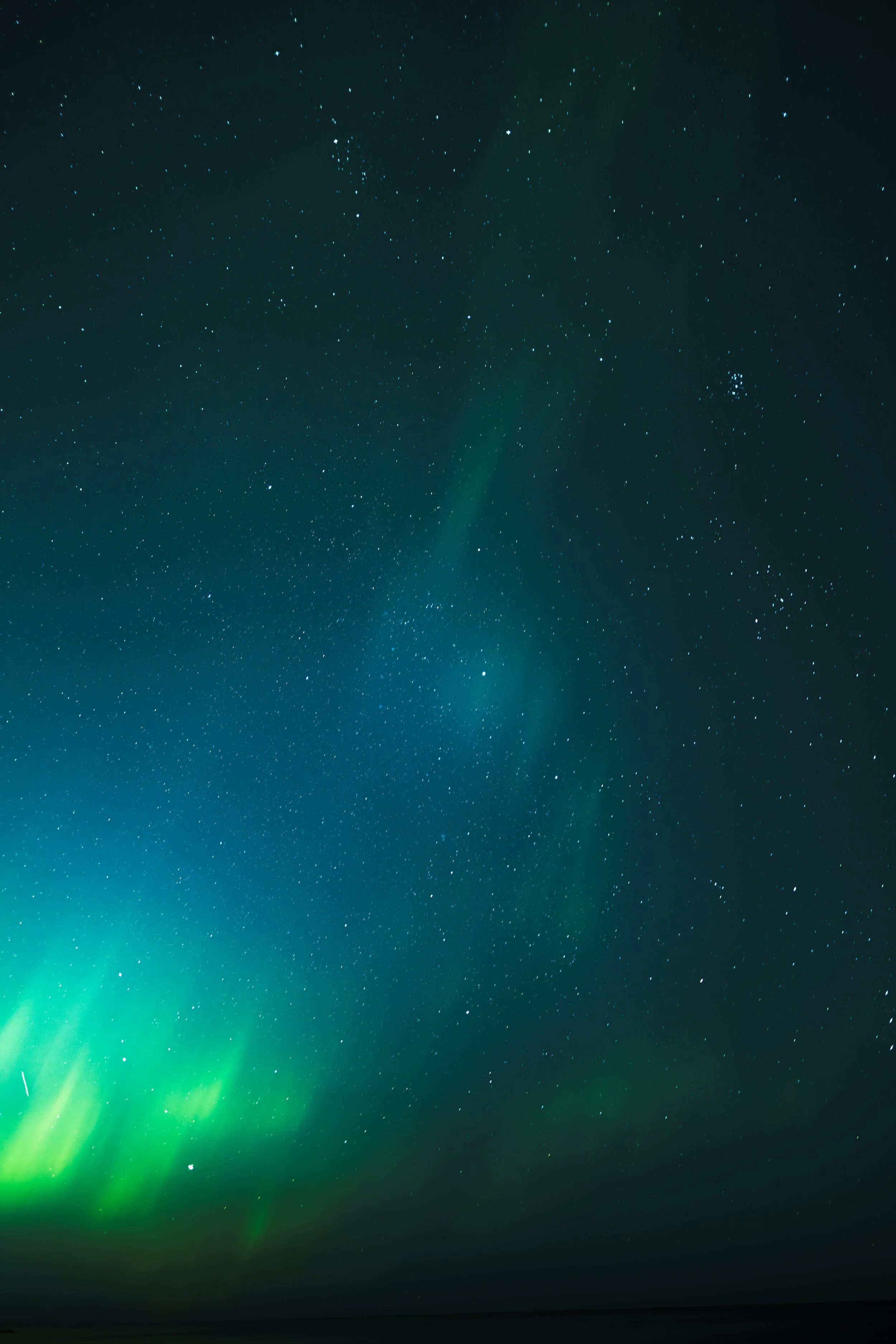 Night sky filled with stars and visible aurora borealis near the horizon.