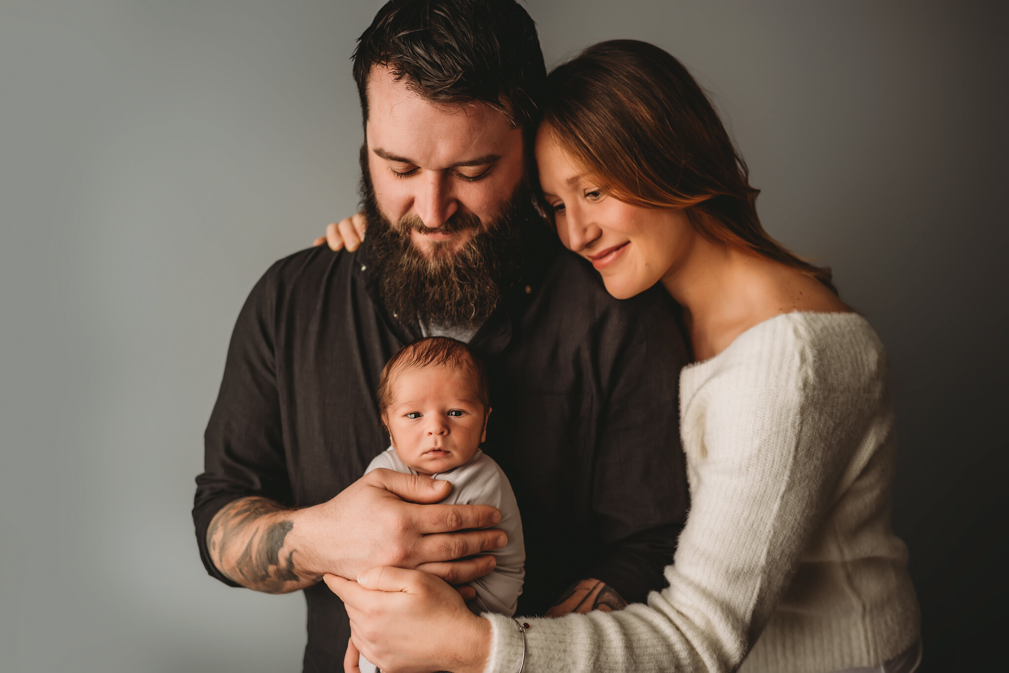 Central IL newborn photographer. Baby looks at camera with mom and dad