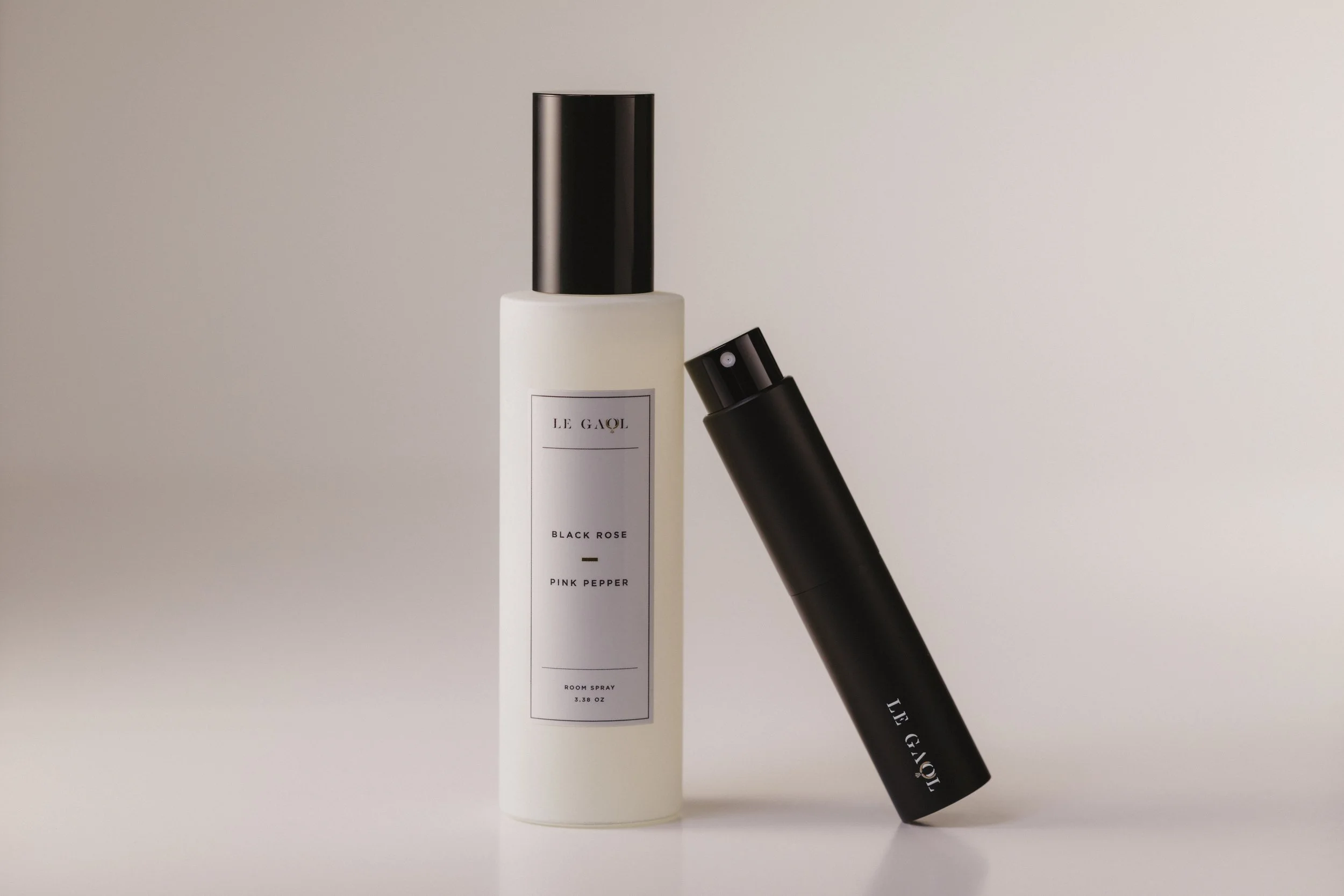 Le Gaol Black Rose + Pink Pepper room and travel sprays against a soft neutral background.