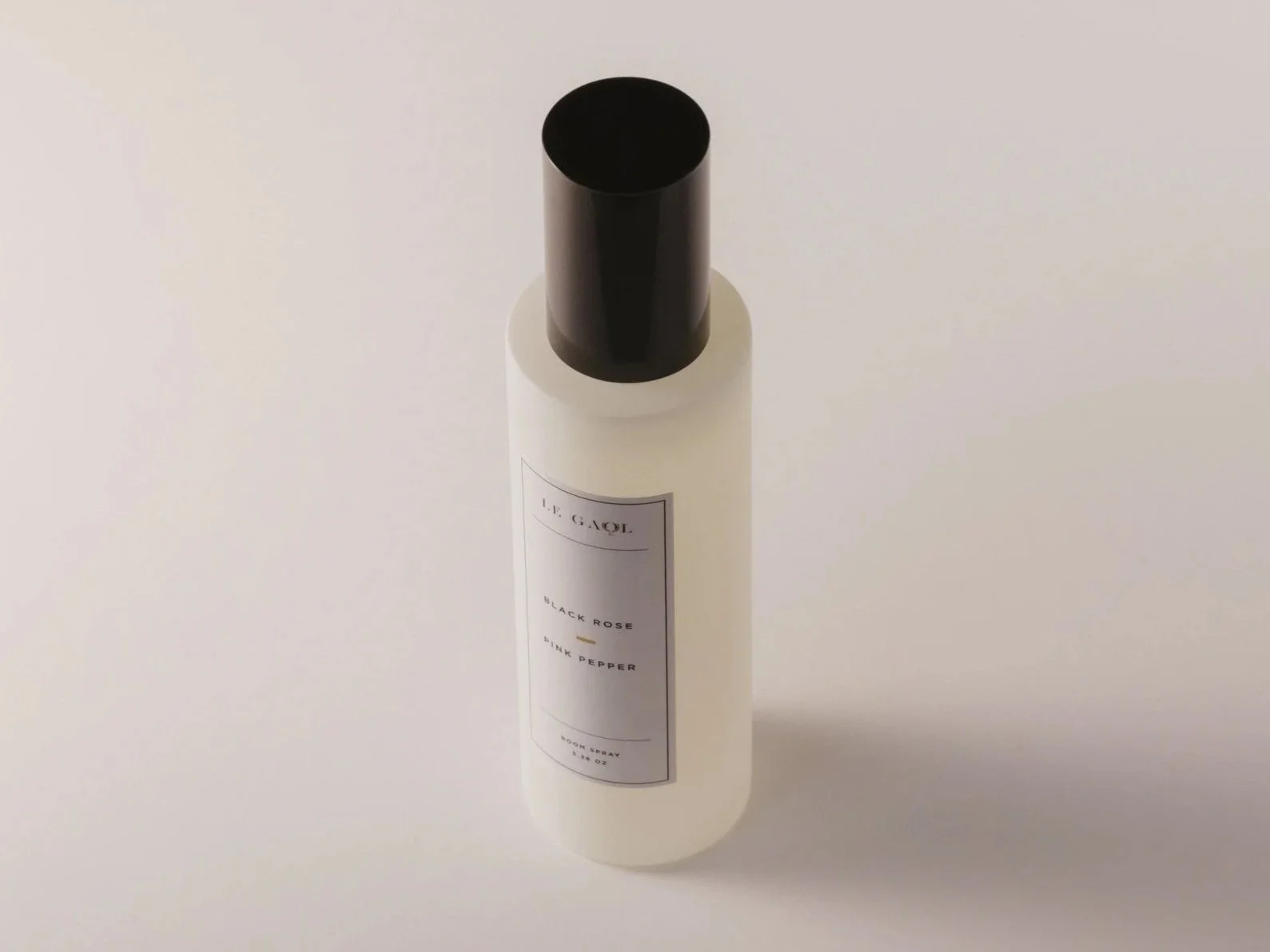 Le Gaol Black Rose + Pink Pepper room and linen spray in a frosted glass bottle with black cap.