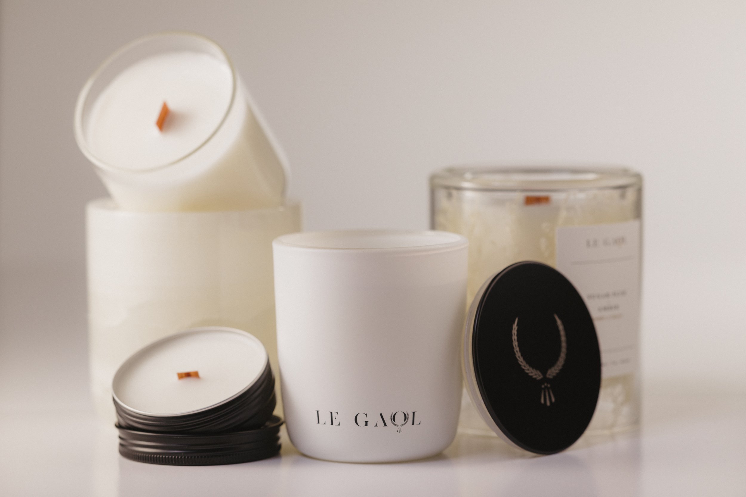 Le Gaol candle collection featuring discovery tins and signature glass candles with wooden wicks.