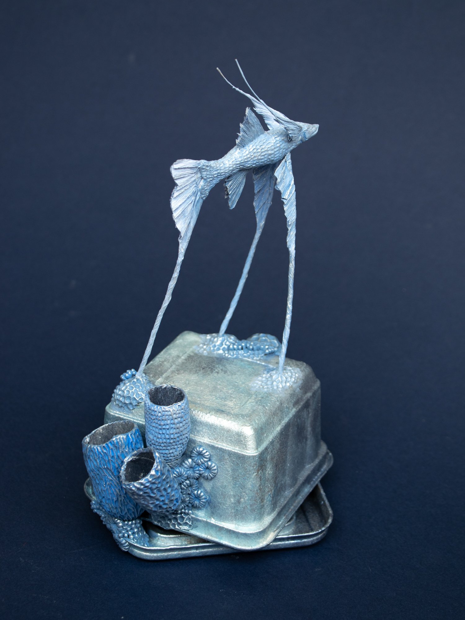 Precarious Balance, Mixed Media Coral and Tripod Fish Sculpture on Trash, 2026, Stephanie Kilgast