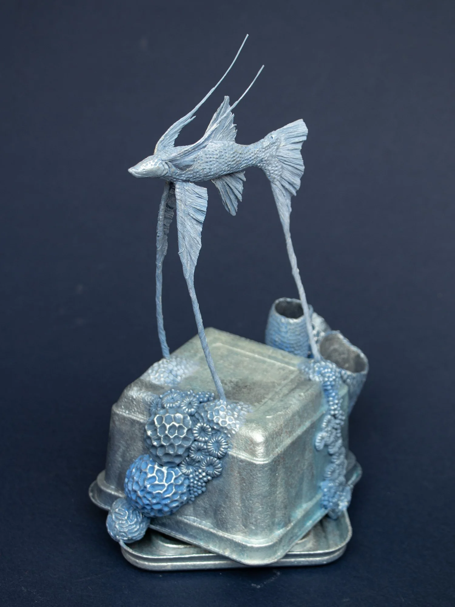 Precarious Balance, Mixed Media Coral and Tripod Fish Sculpture on Trash, 2026, Stephanie Kilgast