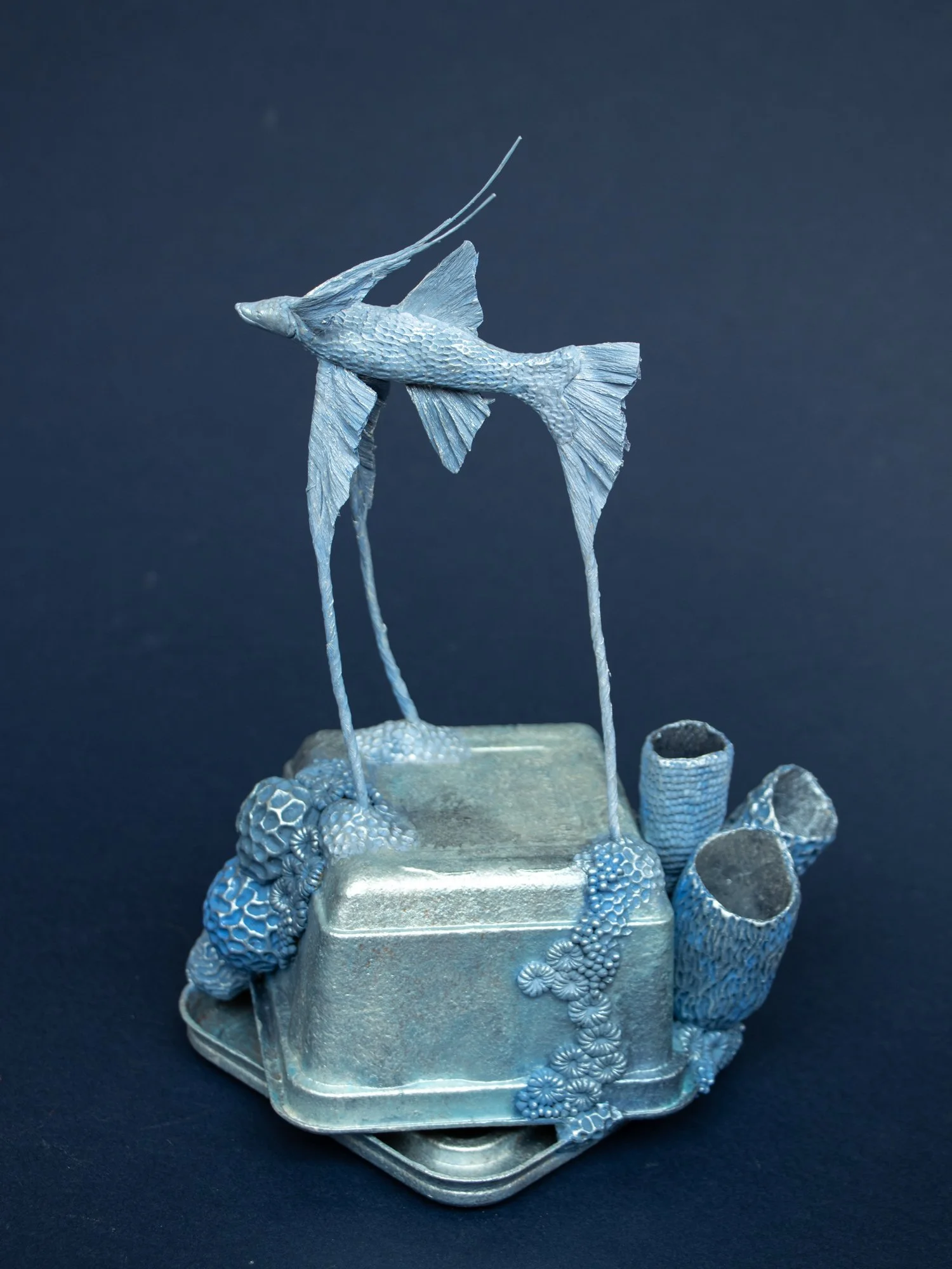Precarious Balance, Mixed Media Coral and Tripod Fish Sculpture on Trash, 2026, Stephanie Kilgast