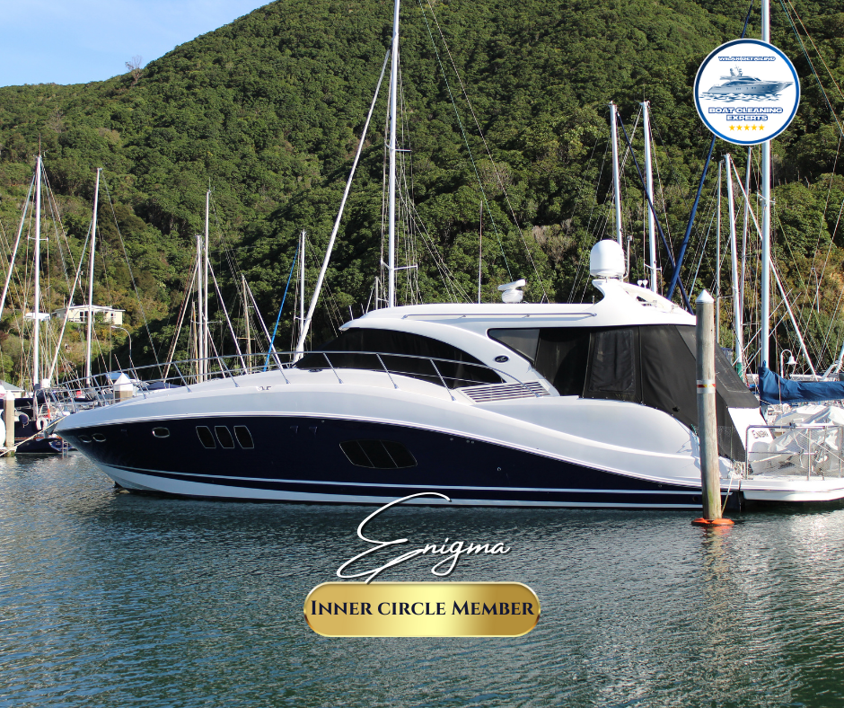 Luxury yacht docked at marina with green hills in the background