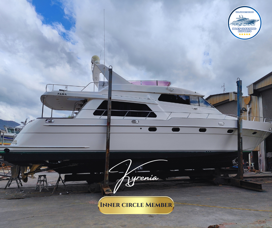 White luxury yacht docked at a marina with hills and blue sky in the background.