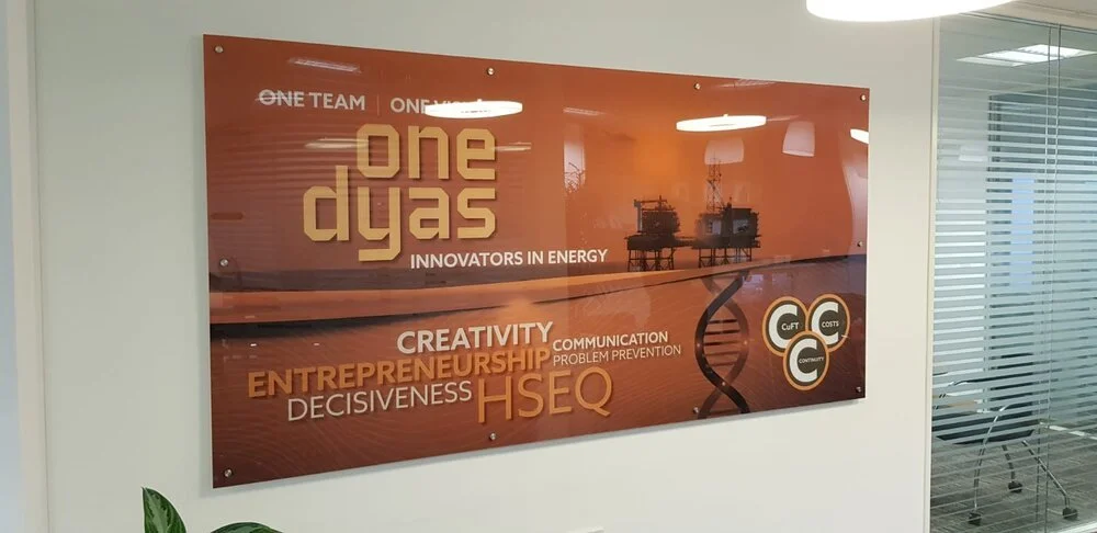 Indoor brown sign mounted on an office wall using stud fixings