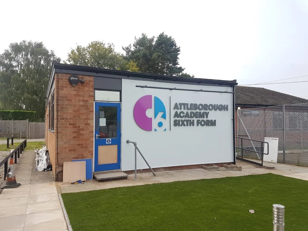 Exterior of attleborough academy sixth form building with blue and white walls featuring the school's logo.