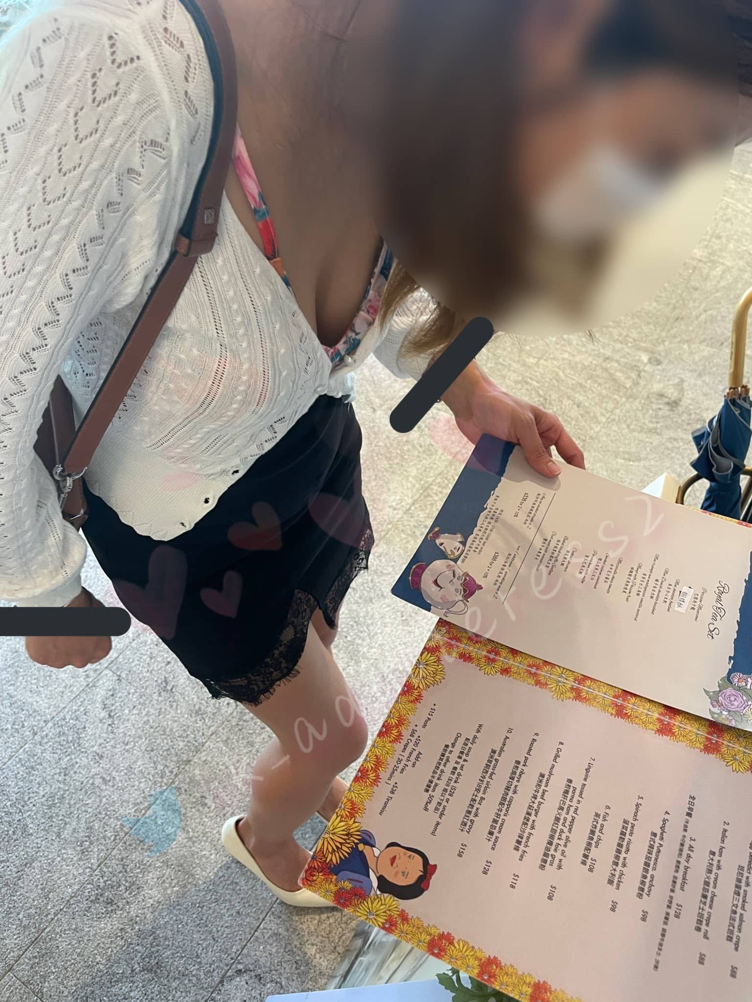 A woman wearing a white lace blouse, black skirt with lace trim, white shoes, and glasses, holding a menu at a restaurant. She has a bag on her shoulder and a mask on her face. The menu features cartoon characters and colorful border designs.