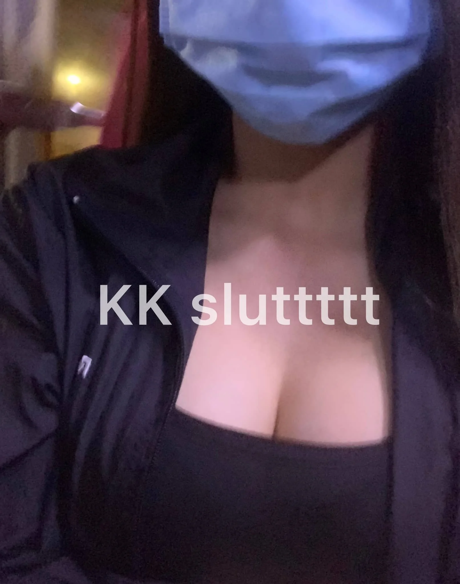 A person wearing a face mask, a black jacket, and a black top, with the text "KK slutt" overlaid on the image.