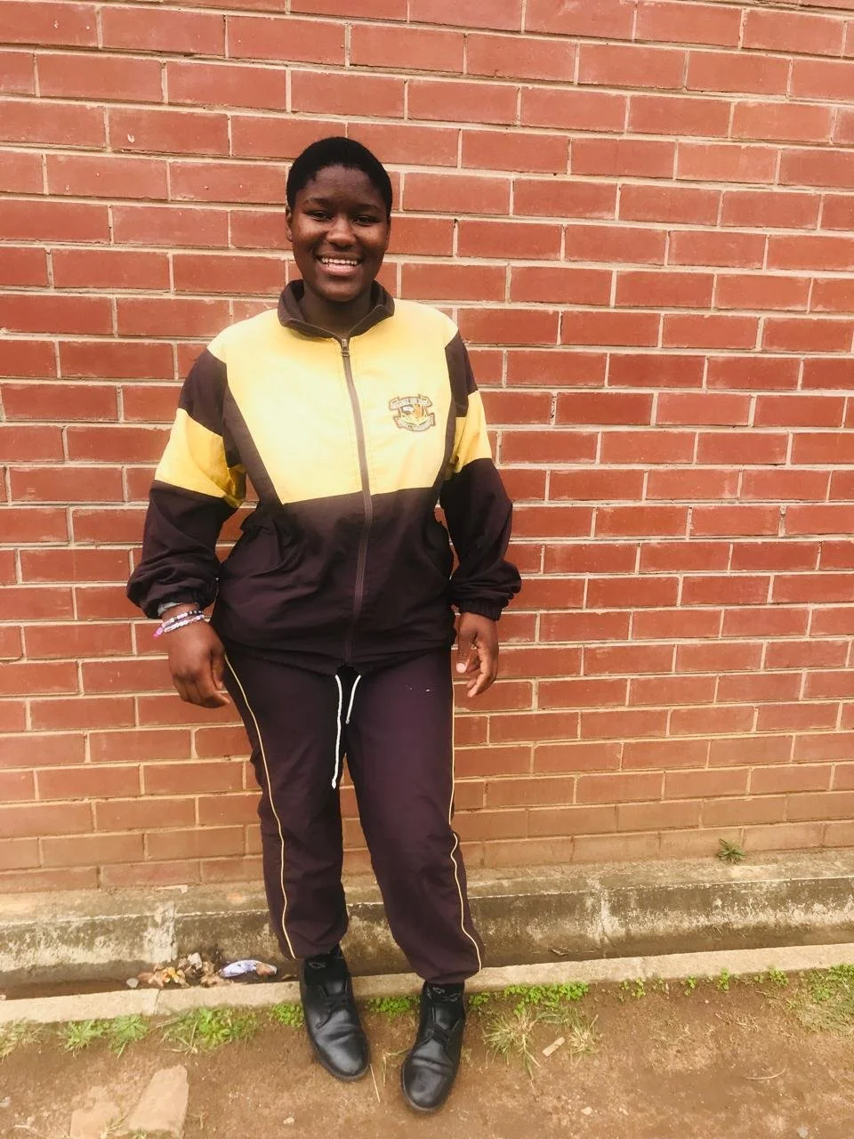 Teenage girl in school uniform with a big smile supported by Back to School
