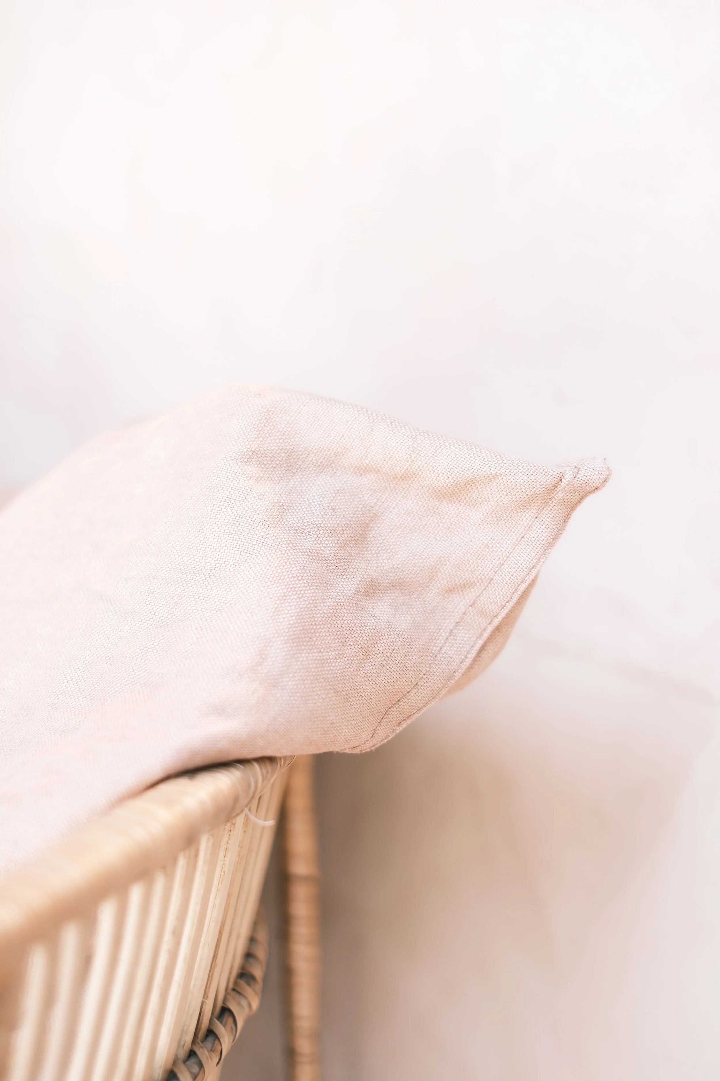 Close-up of a pink fabric draped over a wicker basket.