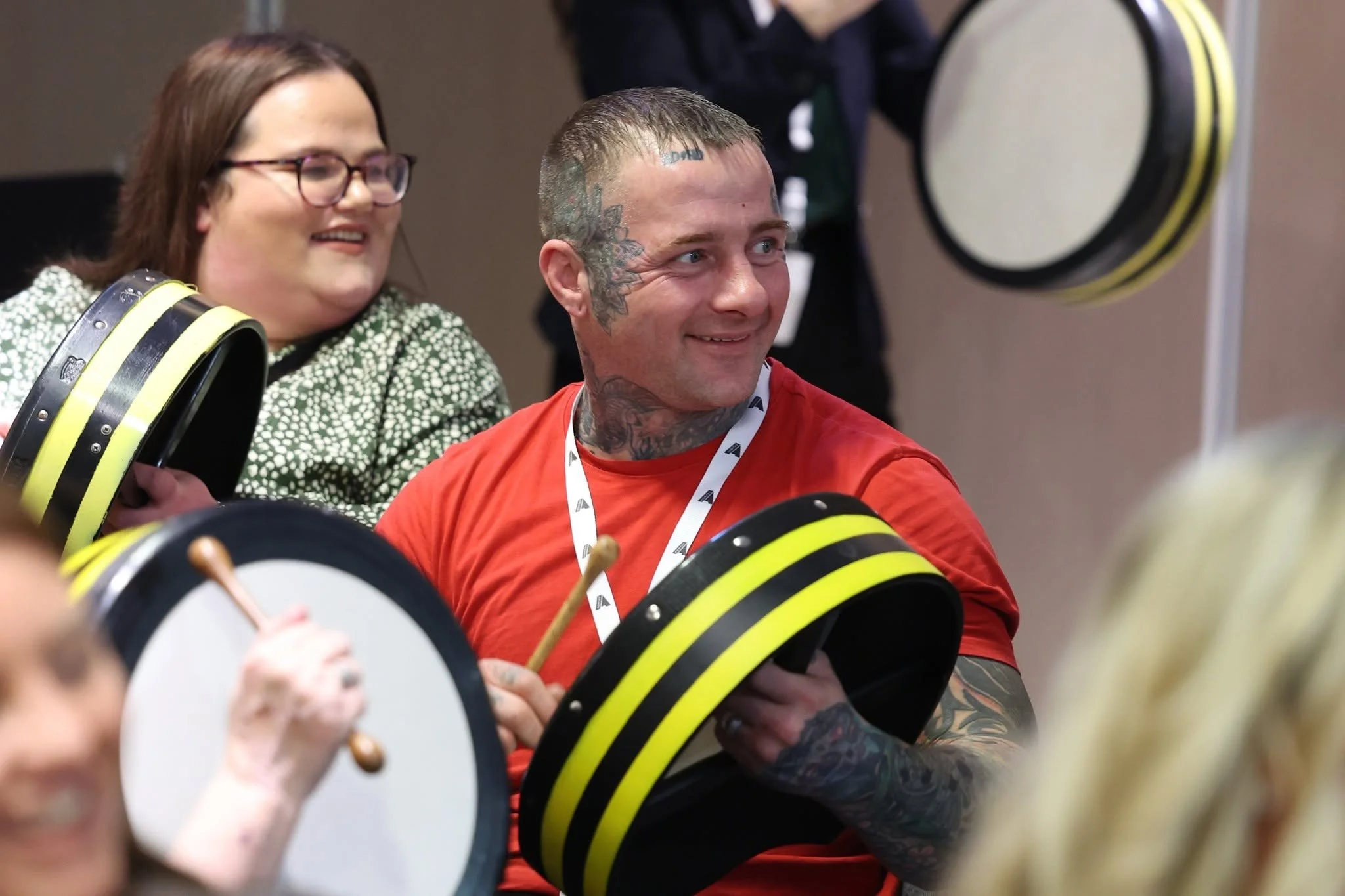 Two bodhran players listening at a workshop