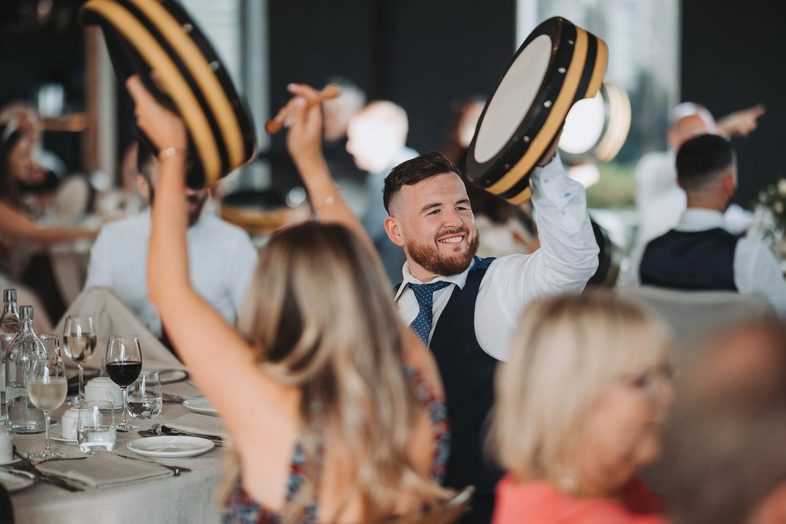 Wedding guests having fun at a bodhran workshop