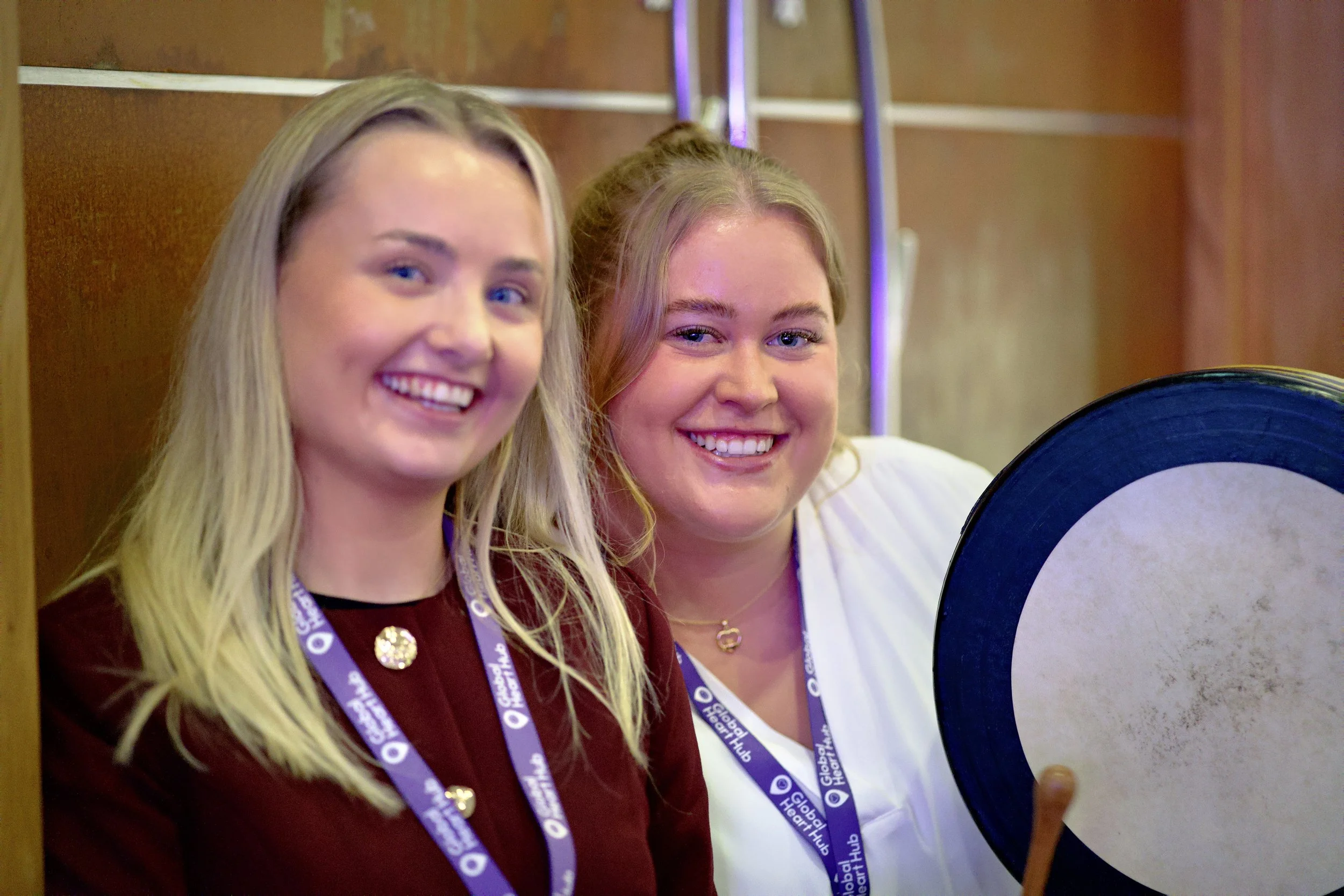 Two women smiling holding a bodhran