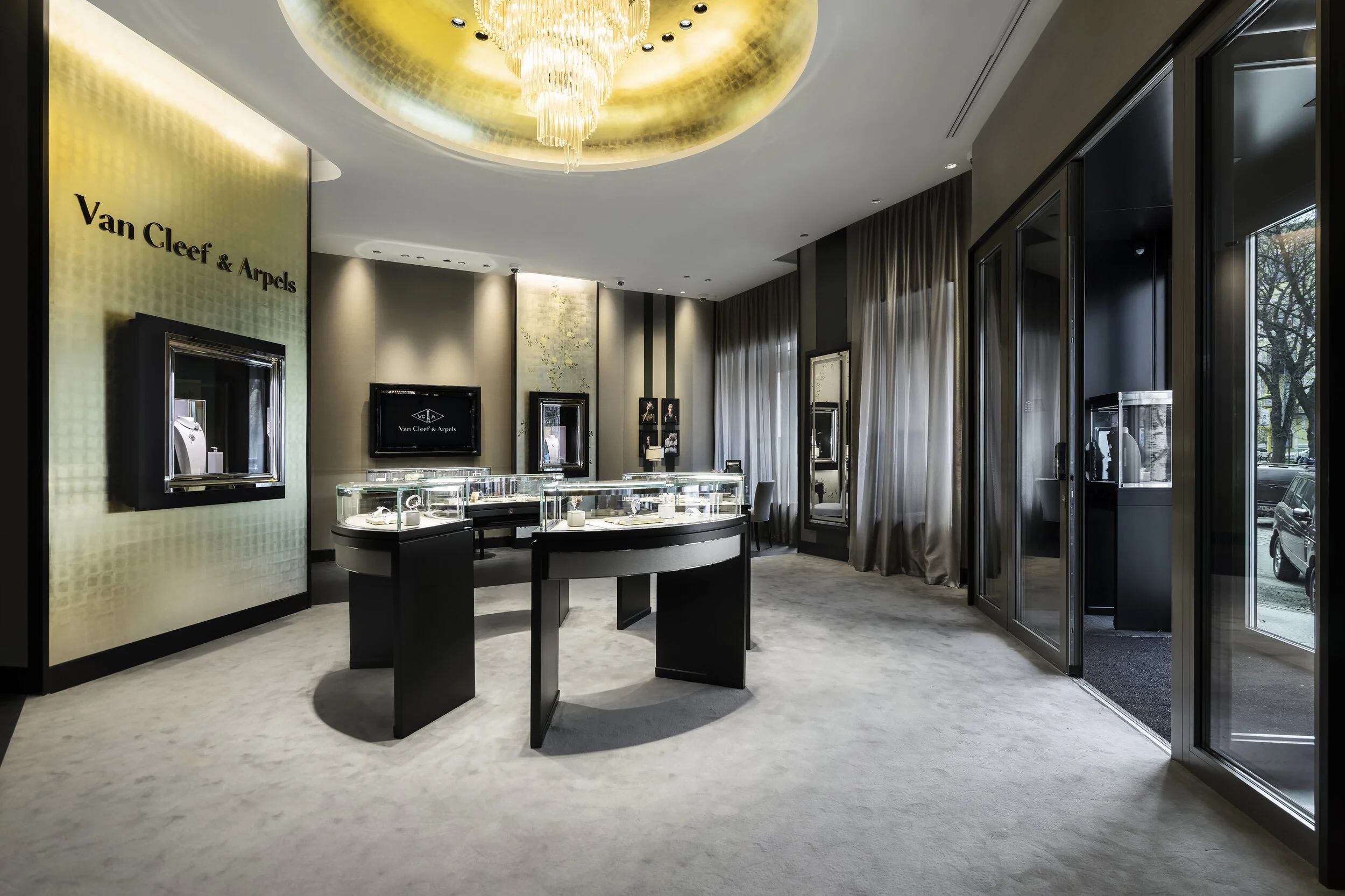 Luxurious Van Cleef & Arpels jewelry store interior with display cases, elegant decor, and a chandelier.