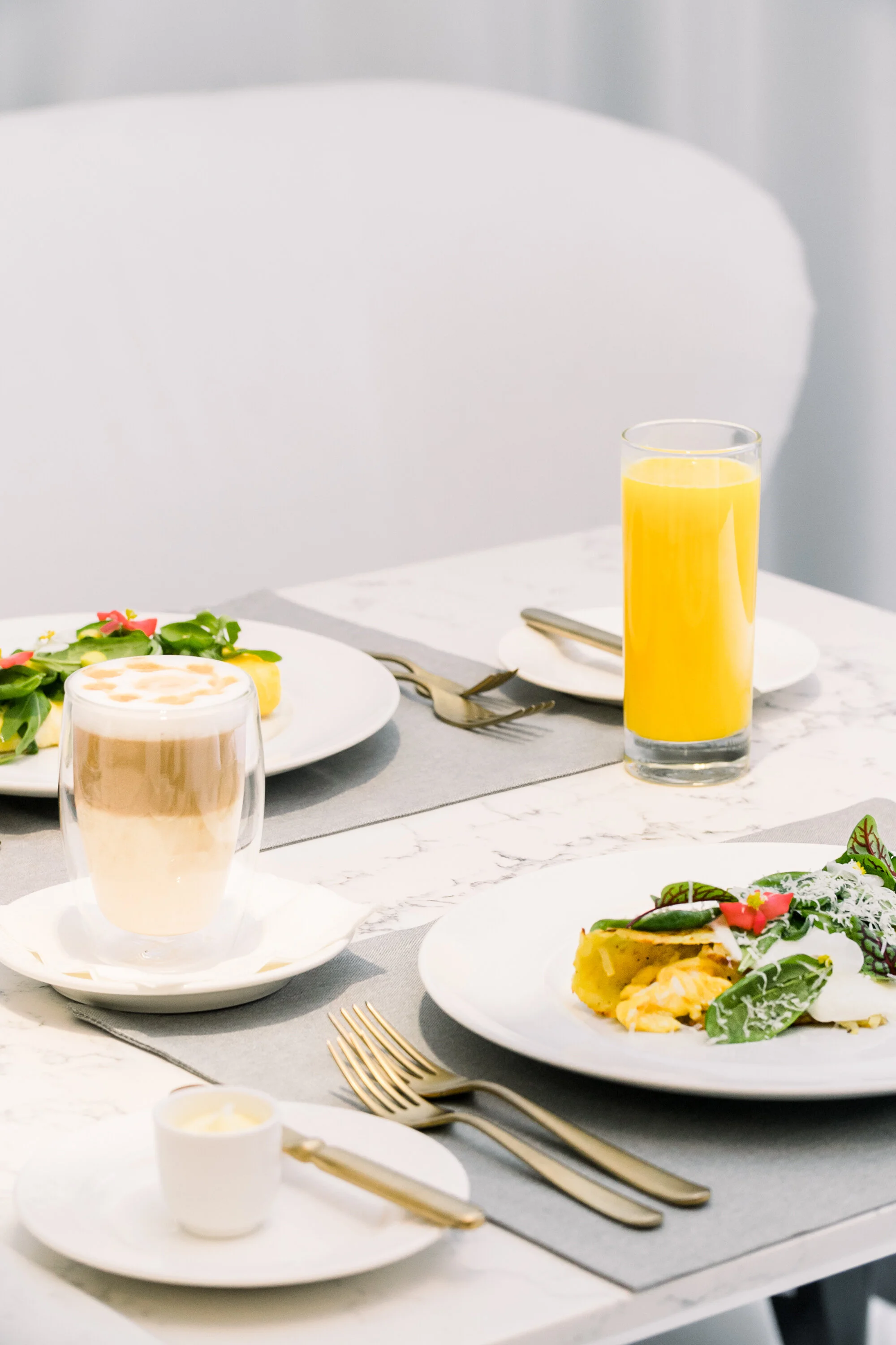 Breakfast setting with coffee, juice, salad, and breakfast dish