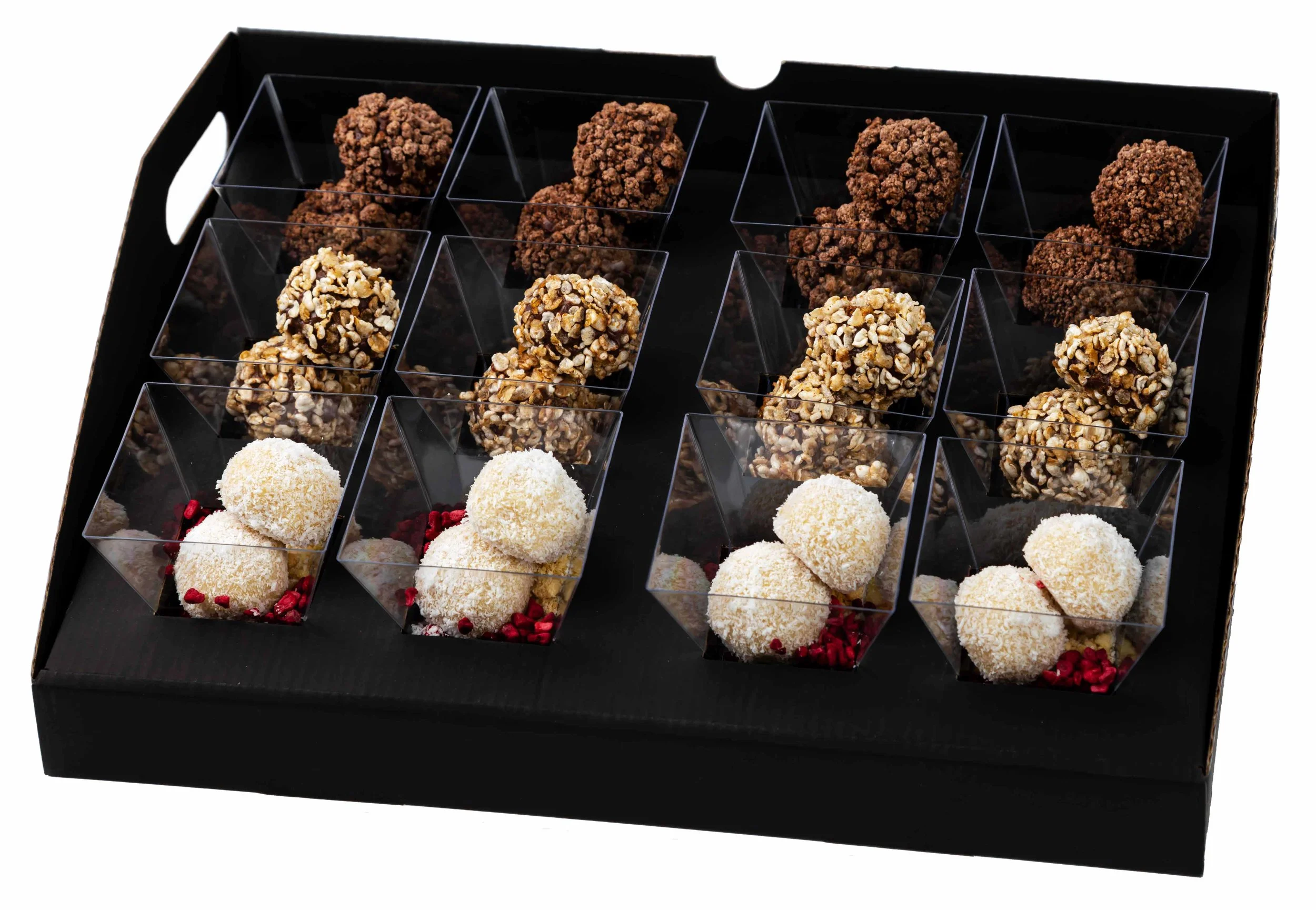 Assorted truffles in clear plastic cups on a black tray, with chocolate, nut, and coconut coatings.