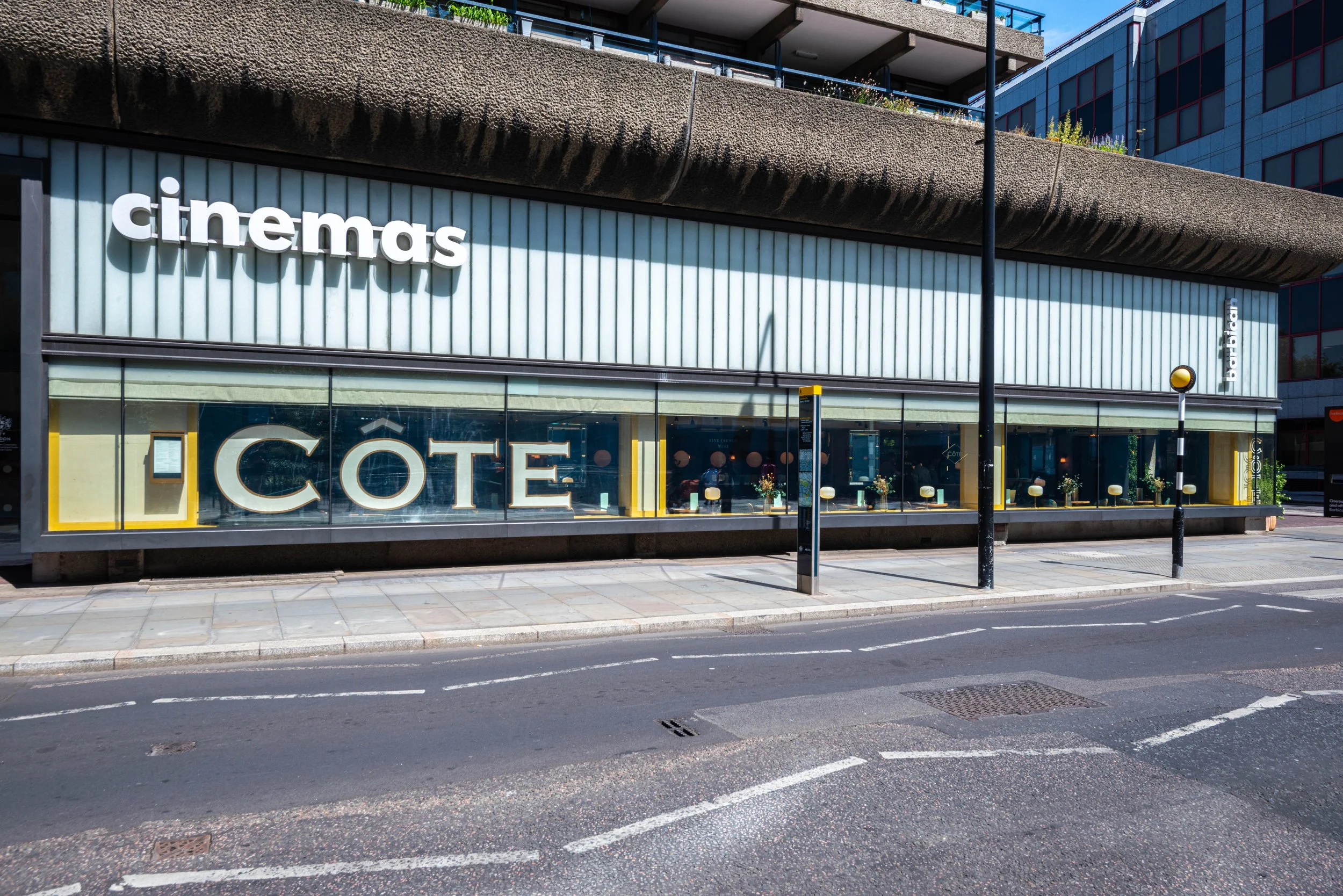 Street view of a building with 'cinemas' and 'CÔTE' signage, featuring a modern facade with large windows.