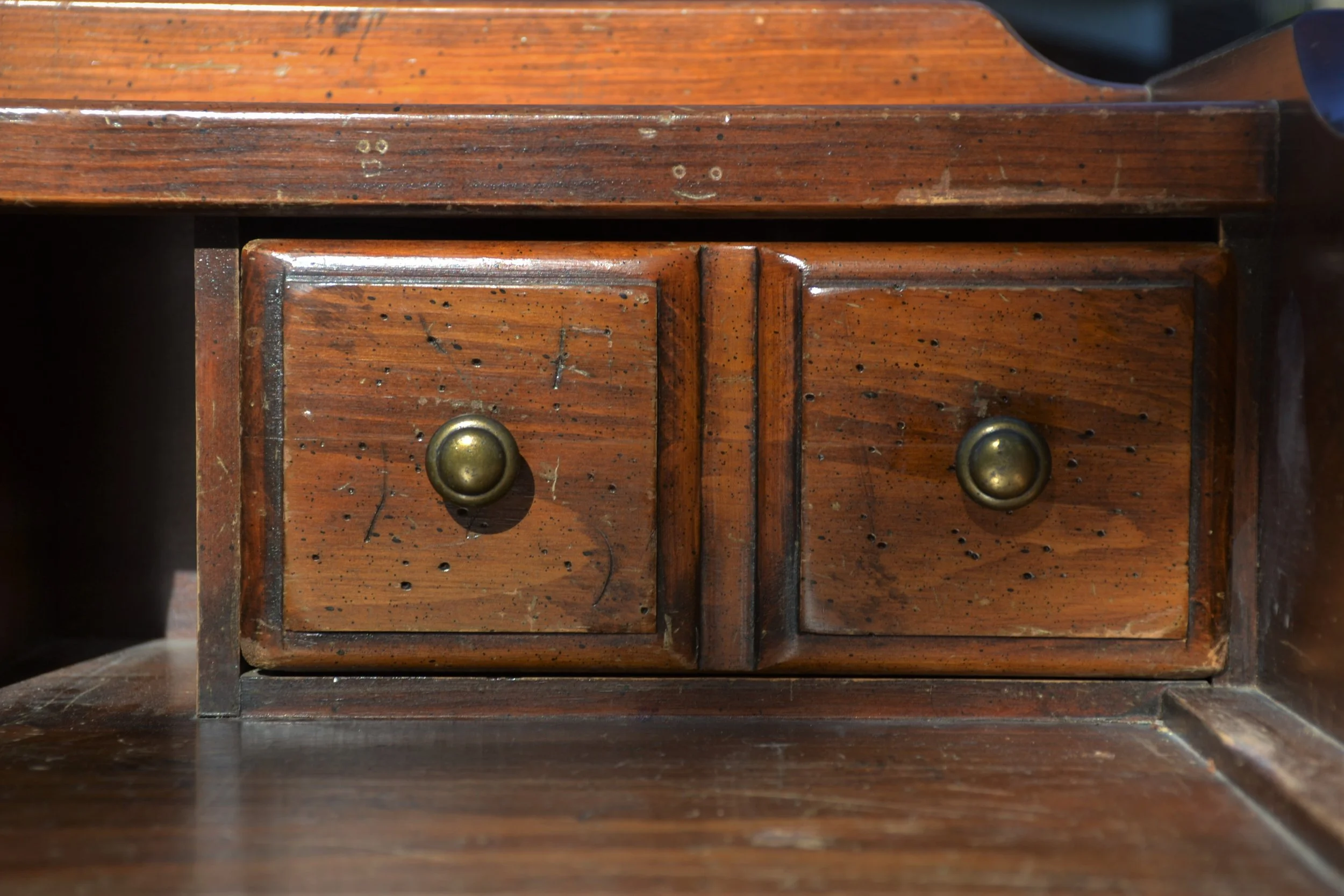 Thrift store wood desk showing wear and damage before flip