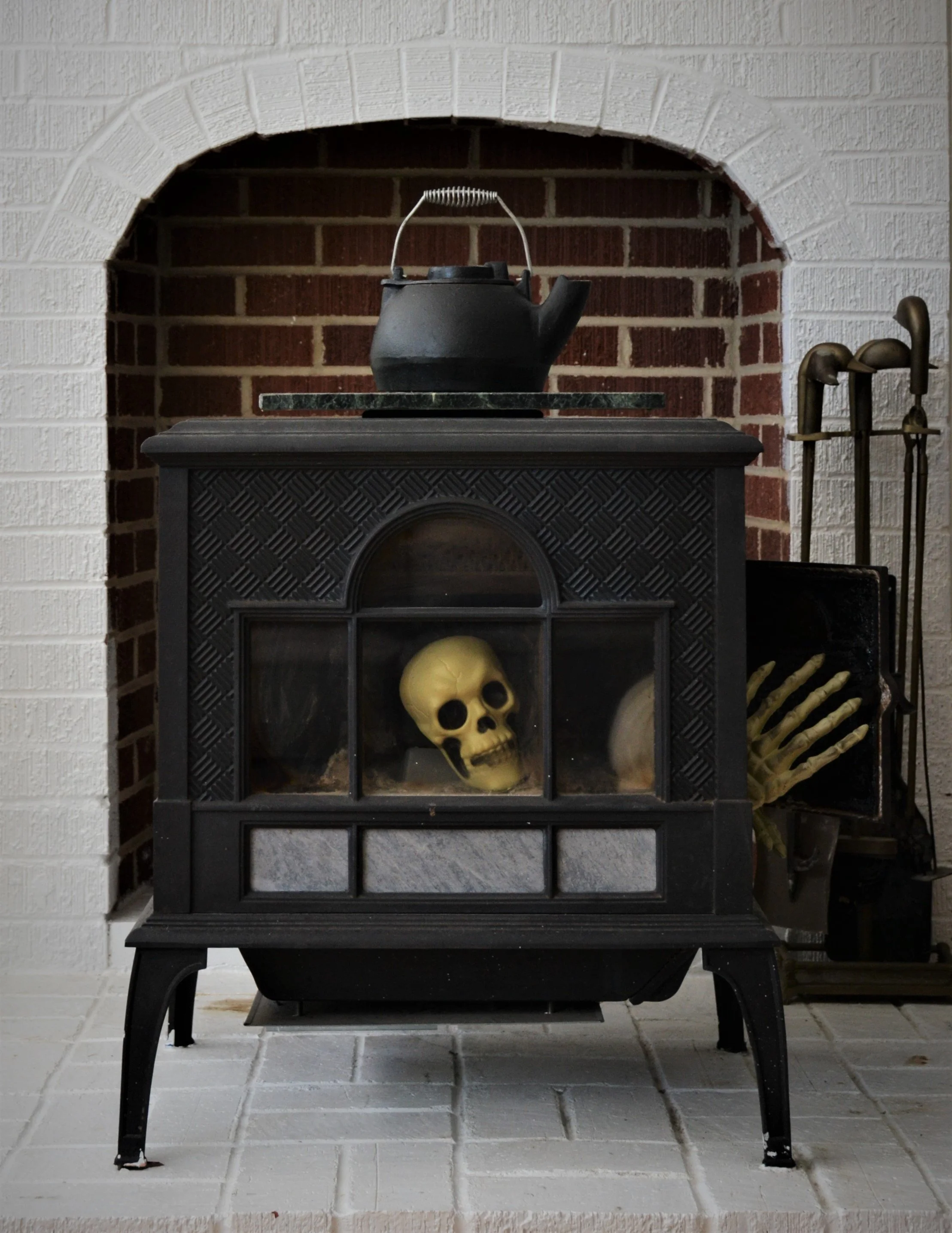  Skull & skeleton hands in wood fire burning stove. 