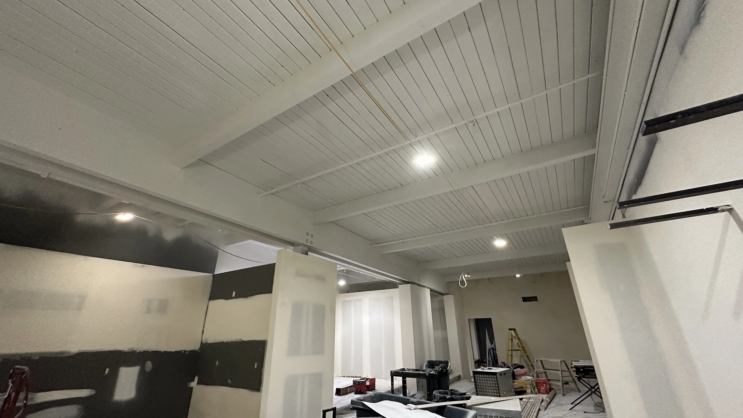 Open-to-structure ceiling spray painting in progress at Schumacher TI in Georgetown, Seattle