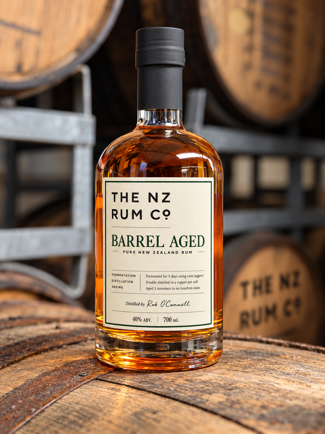 Close up of The NZ Rum Co Barrel Aged Rum bottle, showcasing its premium textured label, embossed lettering and rich amber New Zealand Rum.