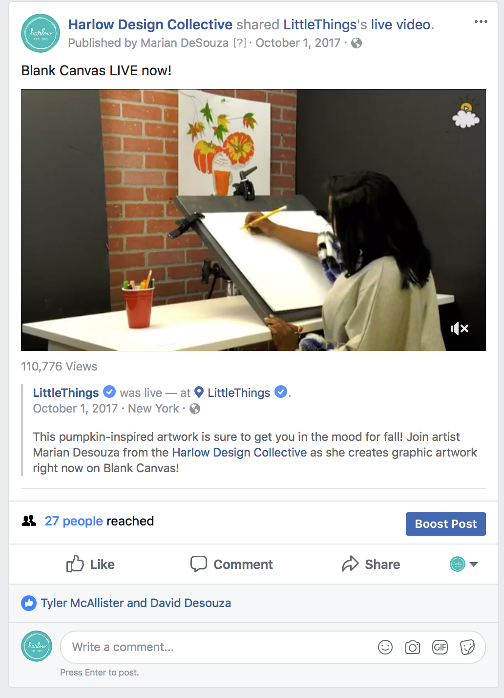 An artist creating pumpkin-inspired artwork on a large drawing pad, with fall-themed decorations hung on the wall behind.