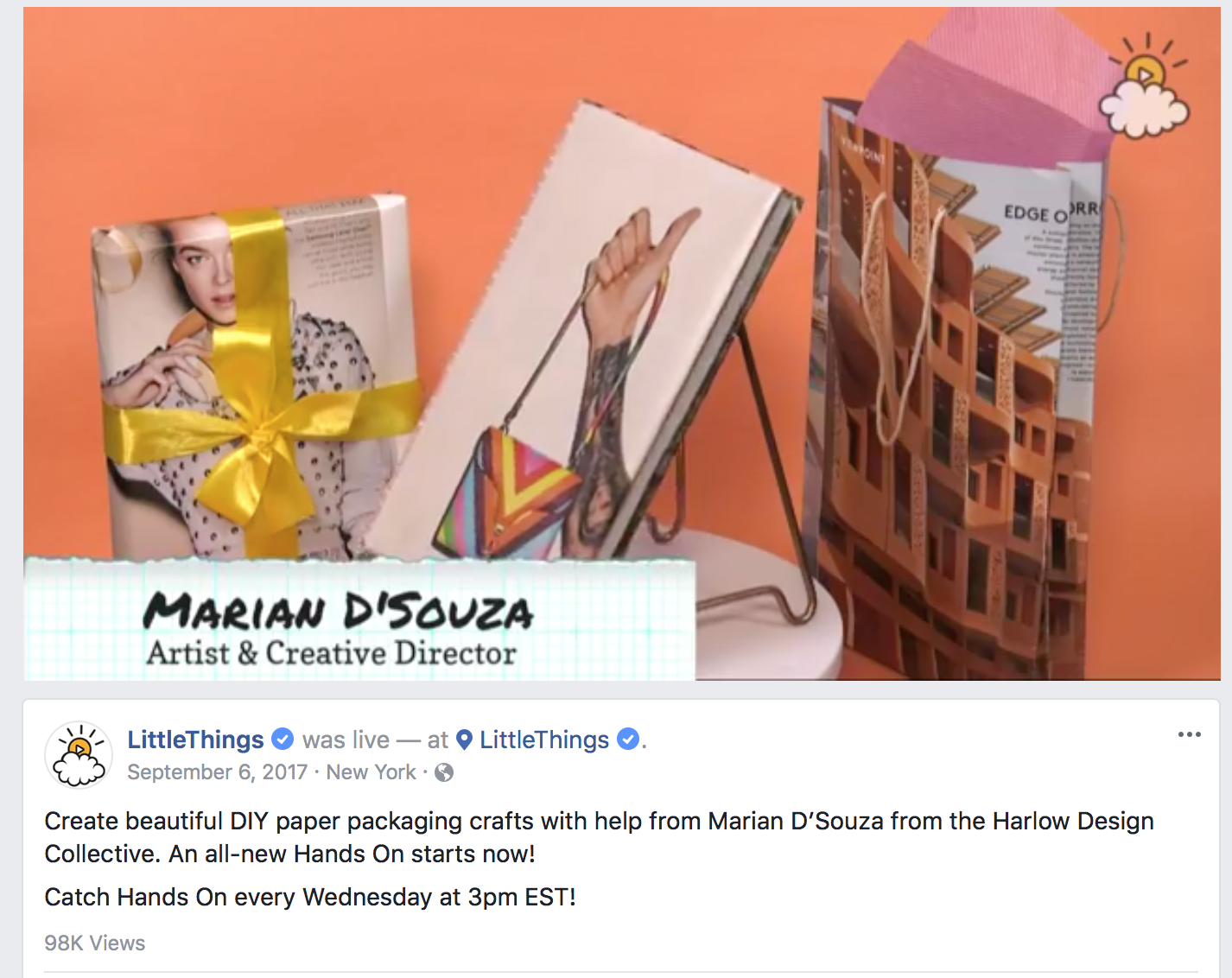 Desk with various DIY paper packaging crafts, including a wrapped gift with a yellow ribbon, an art piece with a tattooed hand holding a colorful geometric clutch, and a cardboard paper bag in the background on a light pink surface.