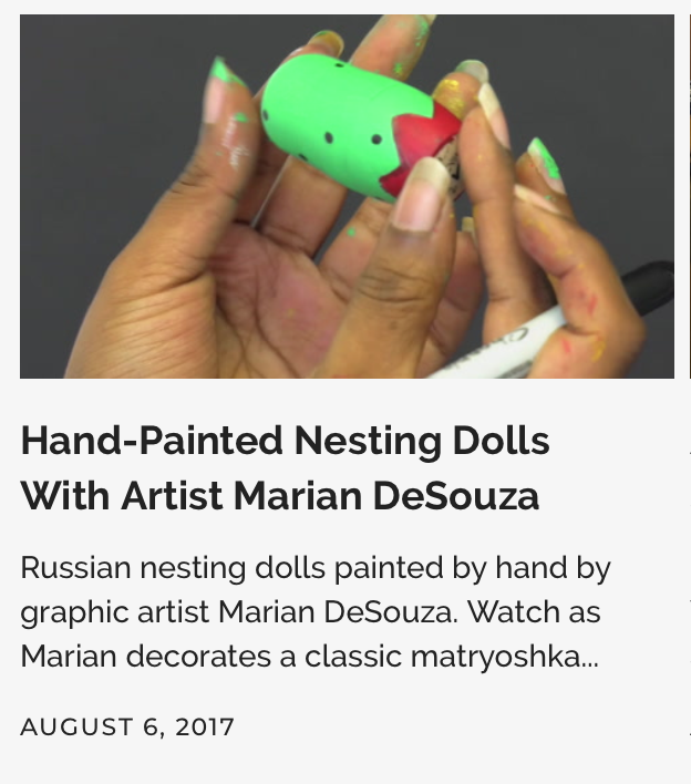 A person's hands painting a green Russian nesting doll with red and black designs.