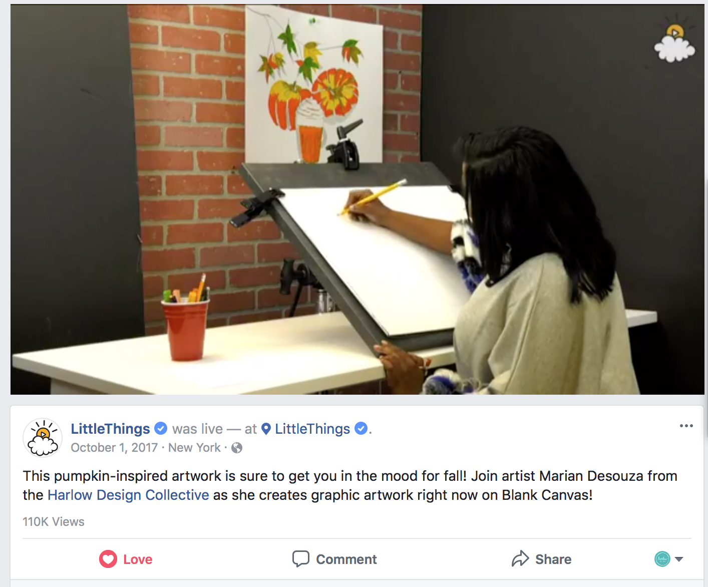 A young girl creates pumpkin-themed artwork on a blank canvas at an adjustable drafting table, with a completed pumpkin painting hanging on a brick wall in the background.