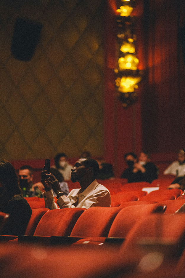 Man in the theatre taking a picture with his phone