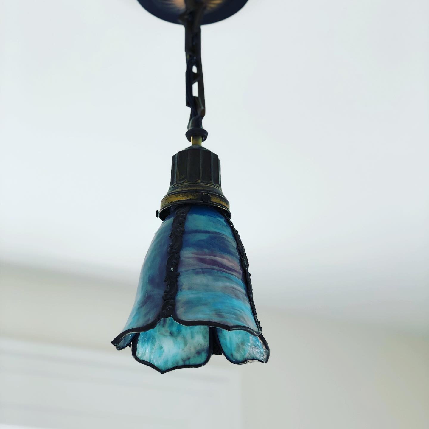 As we dug deep into updating this AMAZING property- we loved finding original pieces we could continue to showcase. 

This light fixture is just one of those pieces. 

I just love the melting of blues &amp; purples in the glass. It is focal point of 