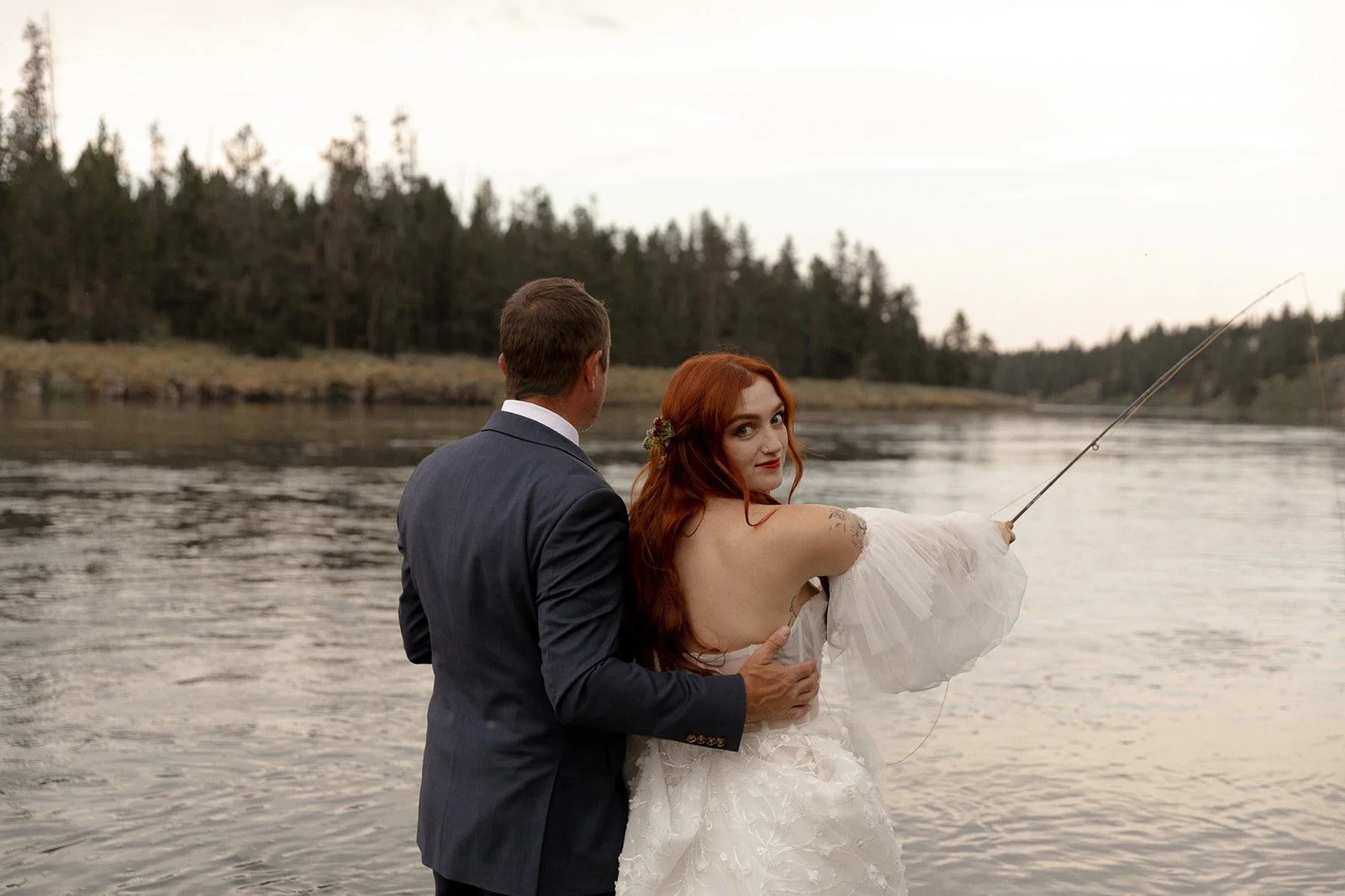Yellowstone wedding photographer captures bride and father fly fishing on the Snake River near Trout Hunter Lodge by Yellowstone National Park