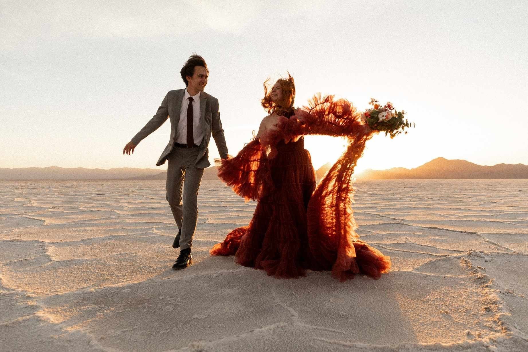 Couple dancing and laughing on the Bonneville Salt Flats at golden hour — Utah elopement photography by Jenna Roden
