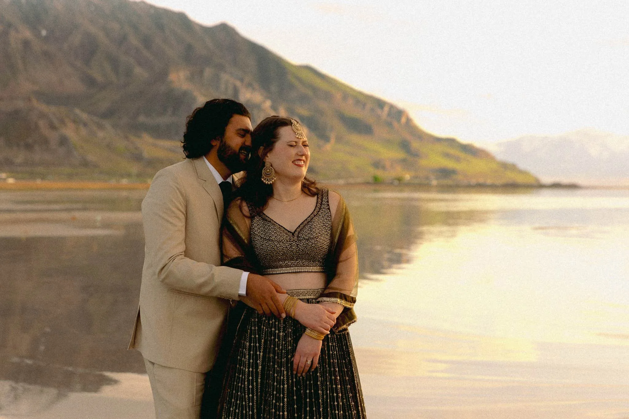 Couple dressed in elegant neutral attire by the Great Salt Air shoreline, example of what to wear for engagement photos with a refined, coastal-inspired look