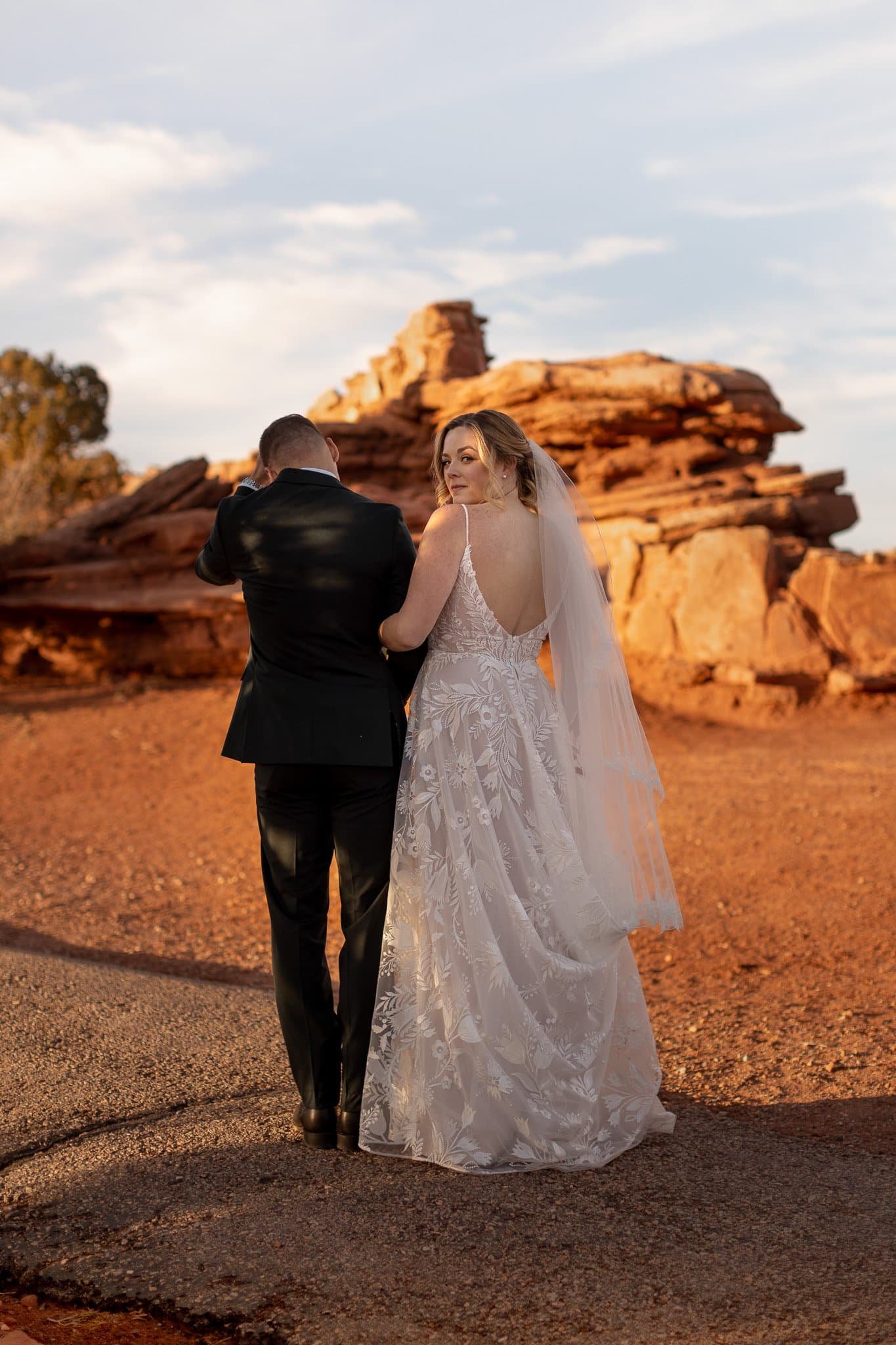 Bride glancing back at Dead Horse State Park near Moab at golden hour — Utah wedding photographer Jenna Roden