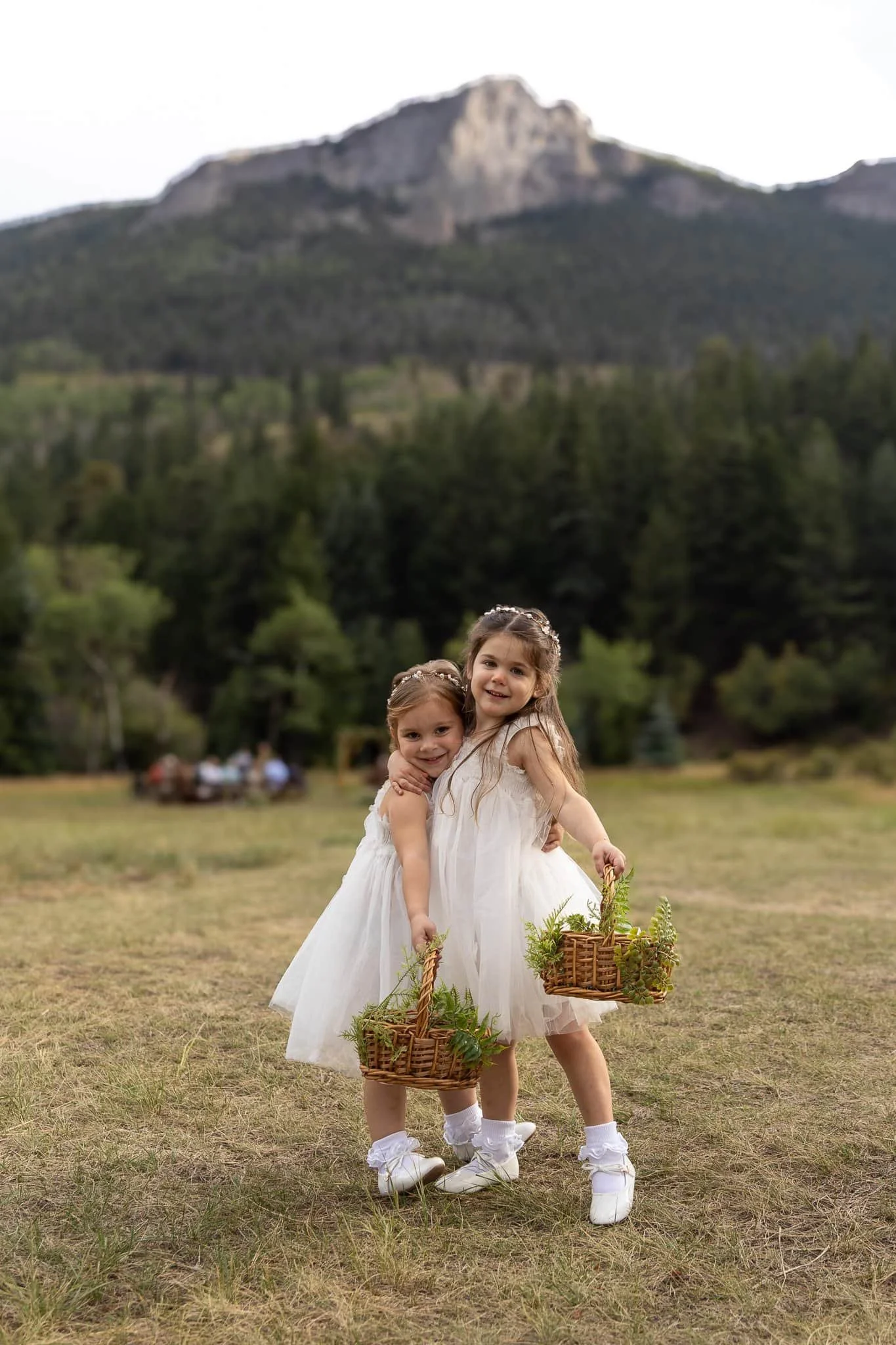 Flower girls at Estes Park wedding with Rocky Mountain backdrop. Colorado Wedding Photographer.