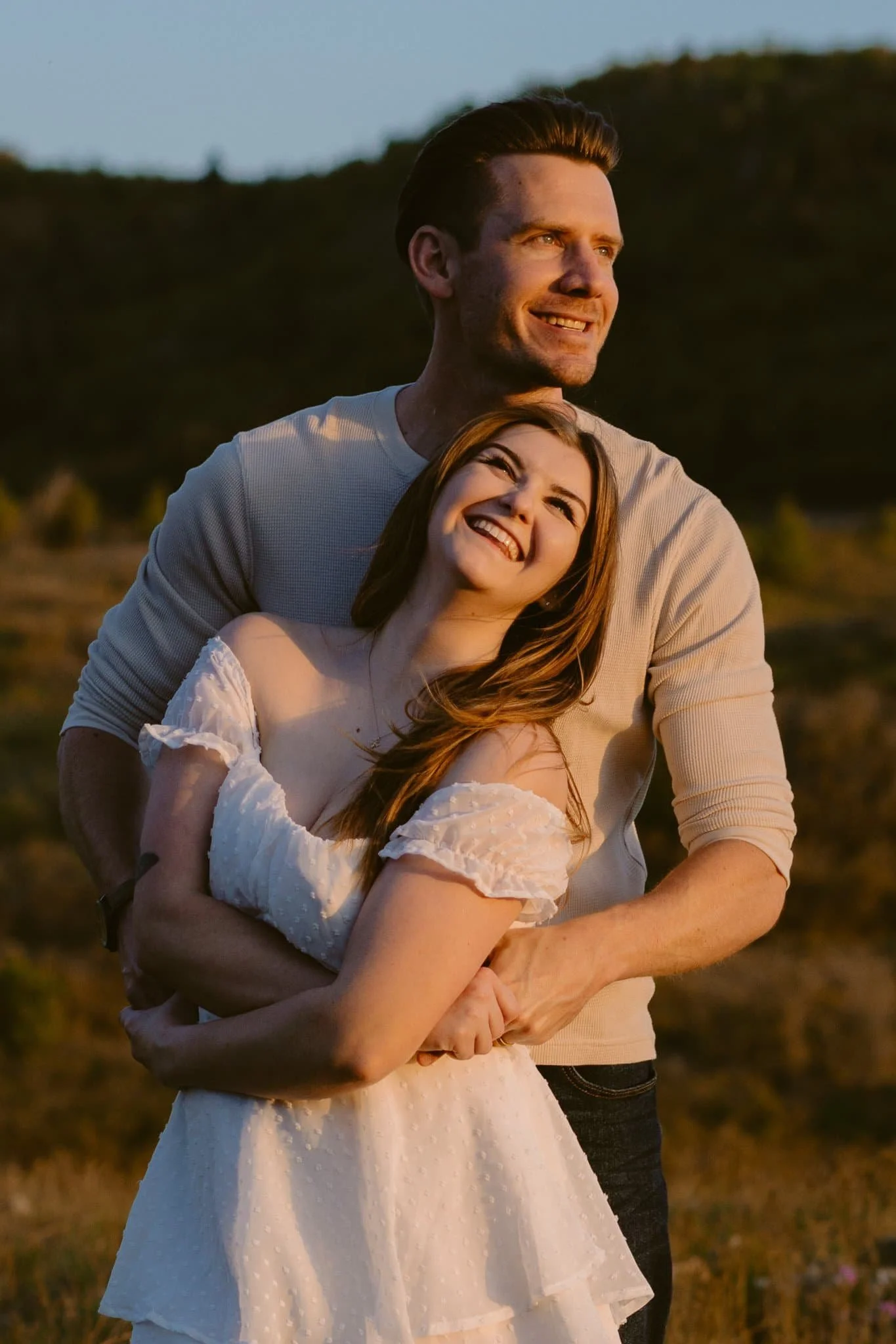 Couple in soft, romantic outfits during golden hour in Provo fields, showcasing what to wear for engagement photos with a light and timeless style