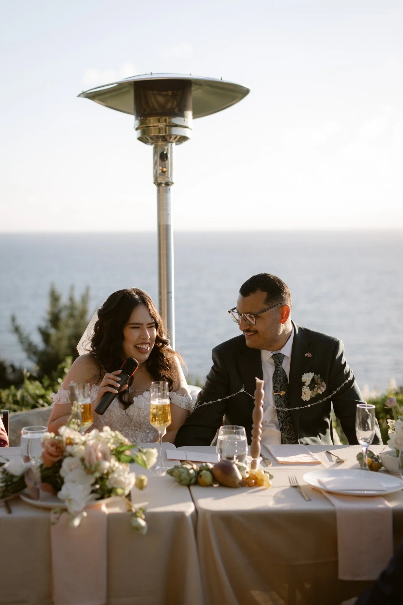 Wind and Sea Estate Big Sur wedding photography pricing — bride laughing at sweetheart table overlooking the Pacific
