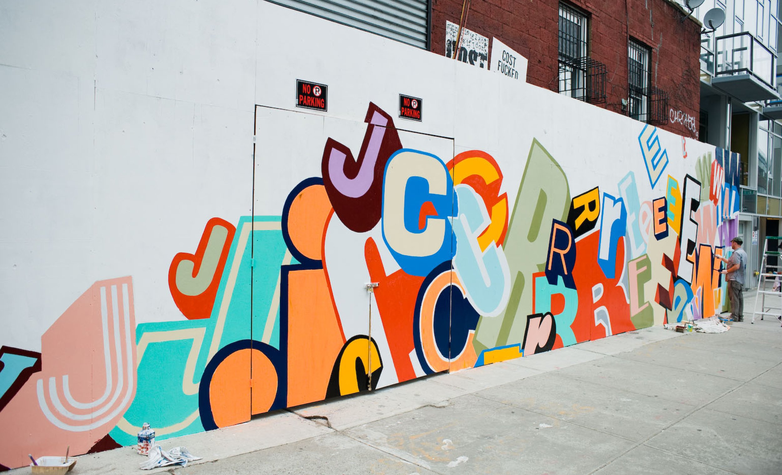Greg Lamarche hand-painting the store barricade - a first clue to arrival in Williamsburg